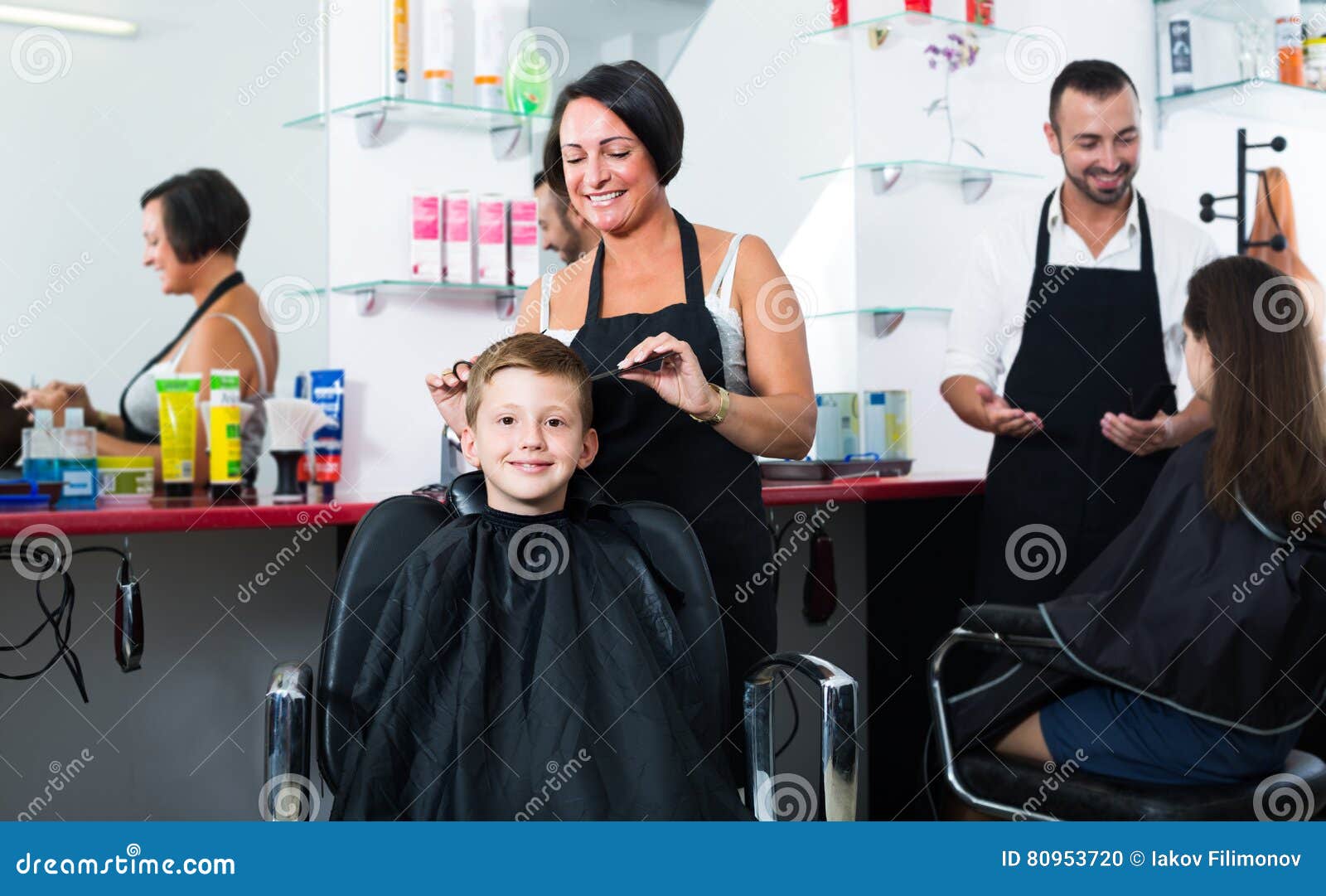 Boy In Elementary School Age Getting Hairdo By Hairdresser Stock