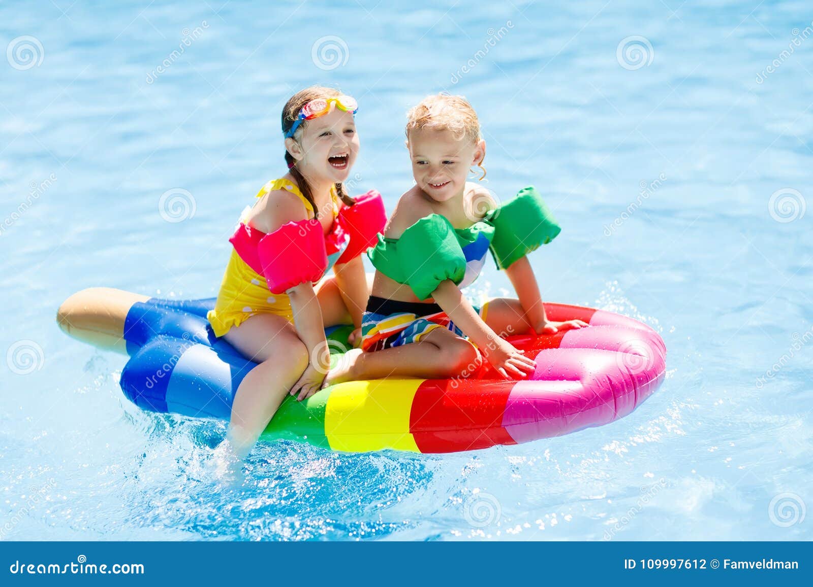 kids on inflatable float in swimming pool.