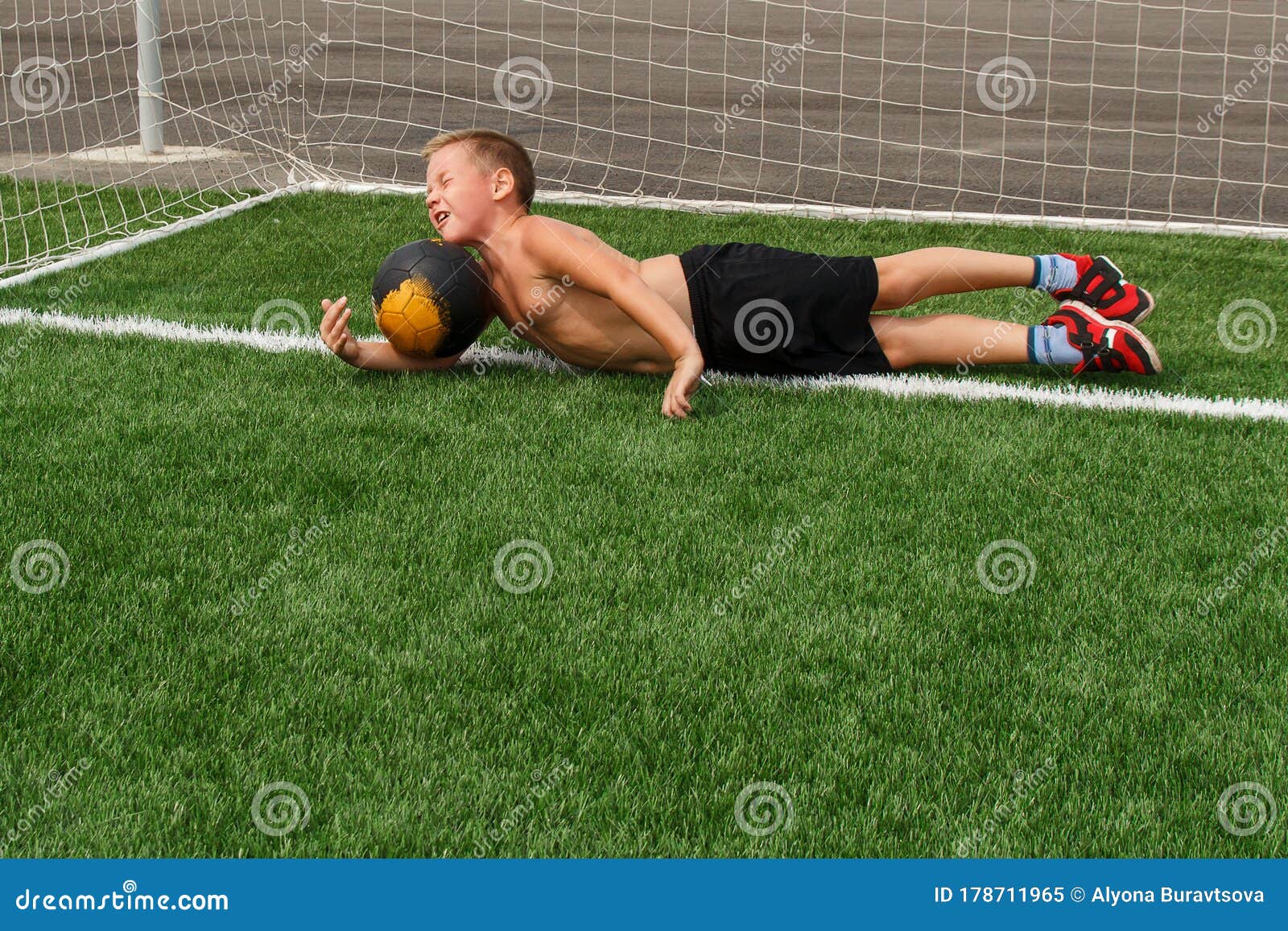 Boy Goalkeeper Catches A Soccer Ball In The Stadium Fall For The Ball The Boy In The Red Shoes Stock Image Image Of Grass Catch