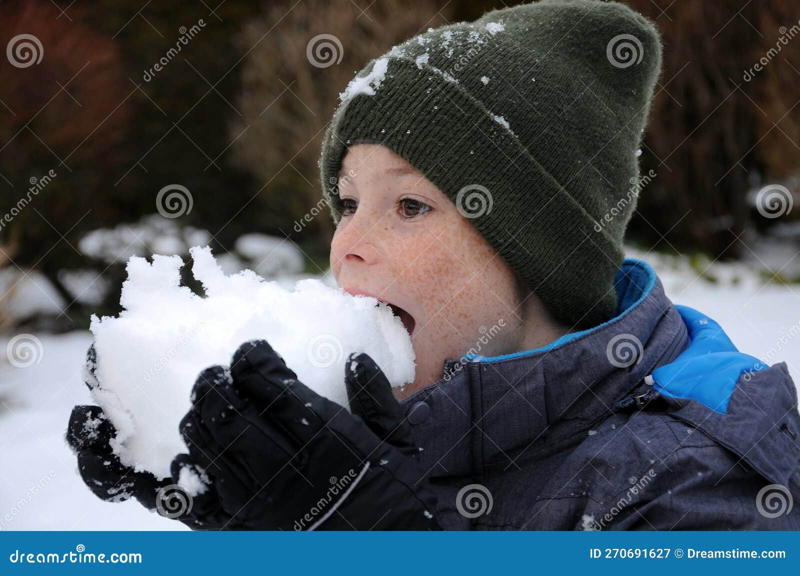 happy wintertime, boy tastes with his tongue the snow