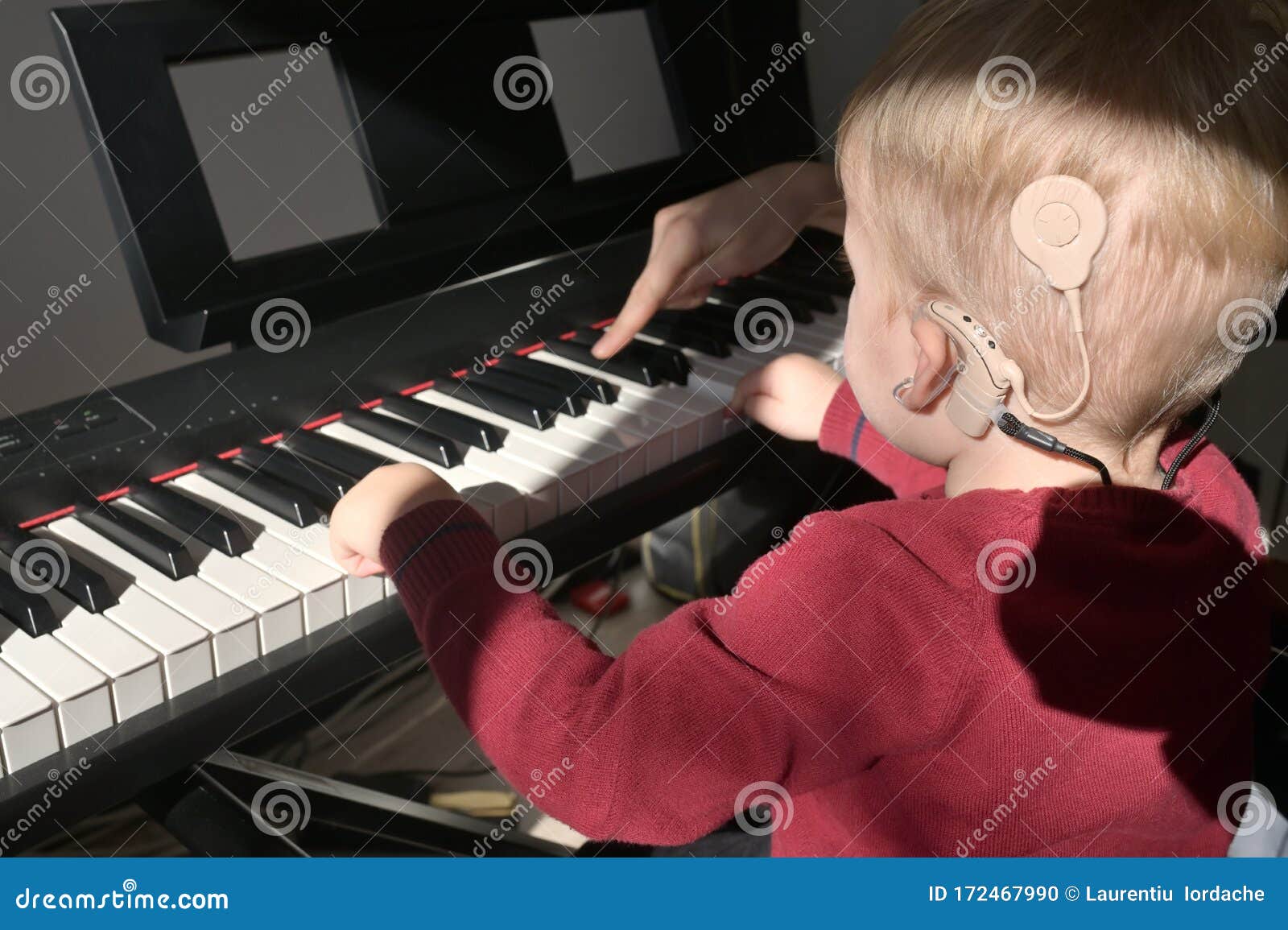 a boy with a hearing aids and cochlear implants playing