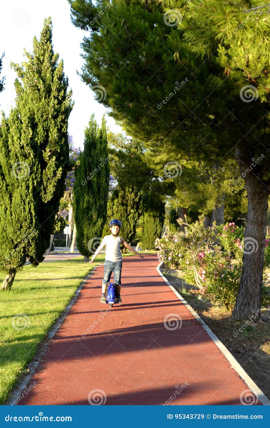 boy with helmet is riding monowheel on promenade