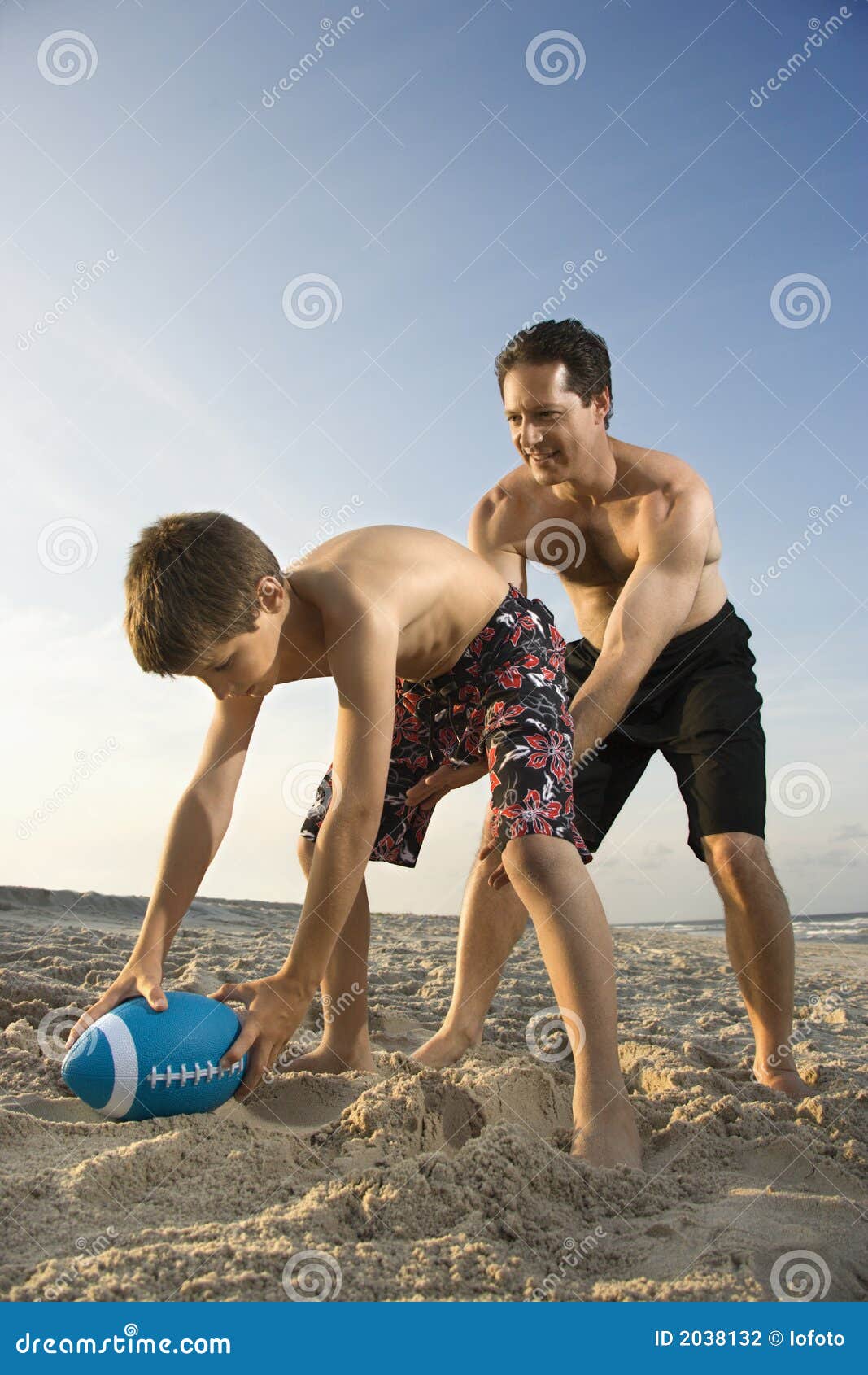 Boy Hiking Football To His Dad Stoc