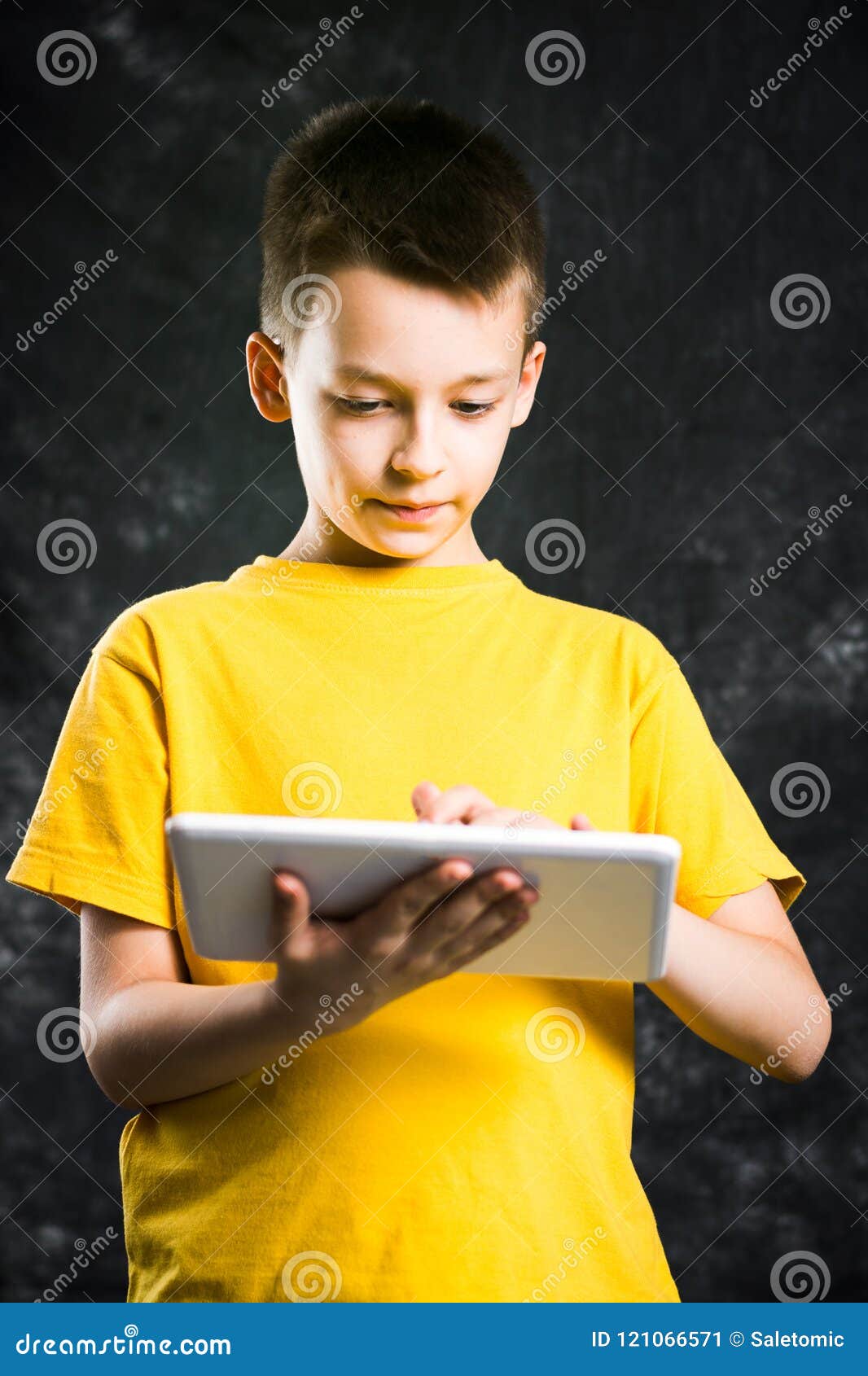 Boy Holding a Tablet Device Against Dark Background Stock Image - Image ...