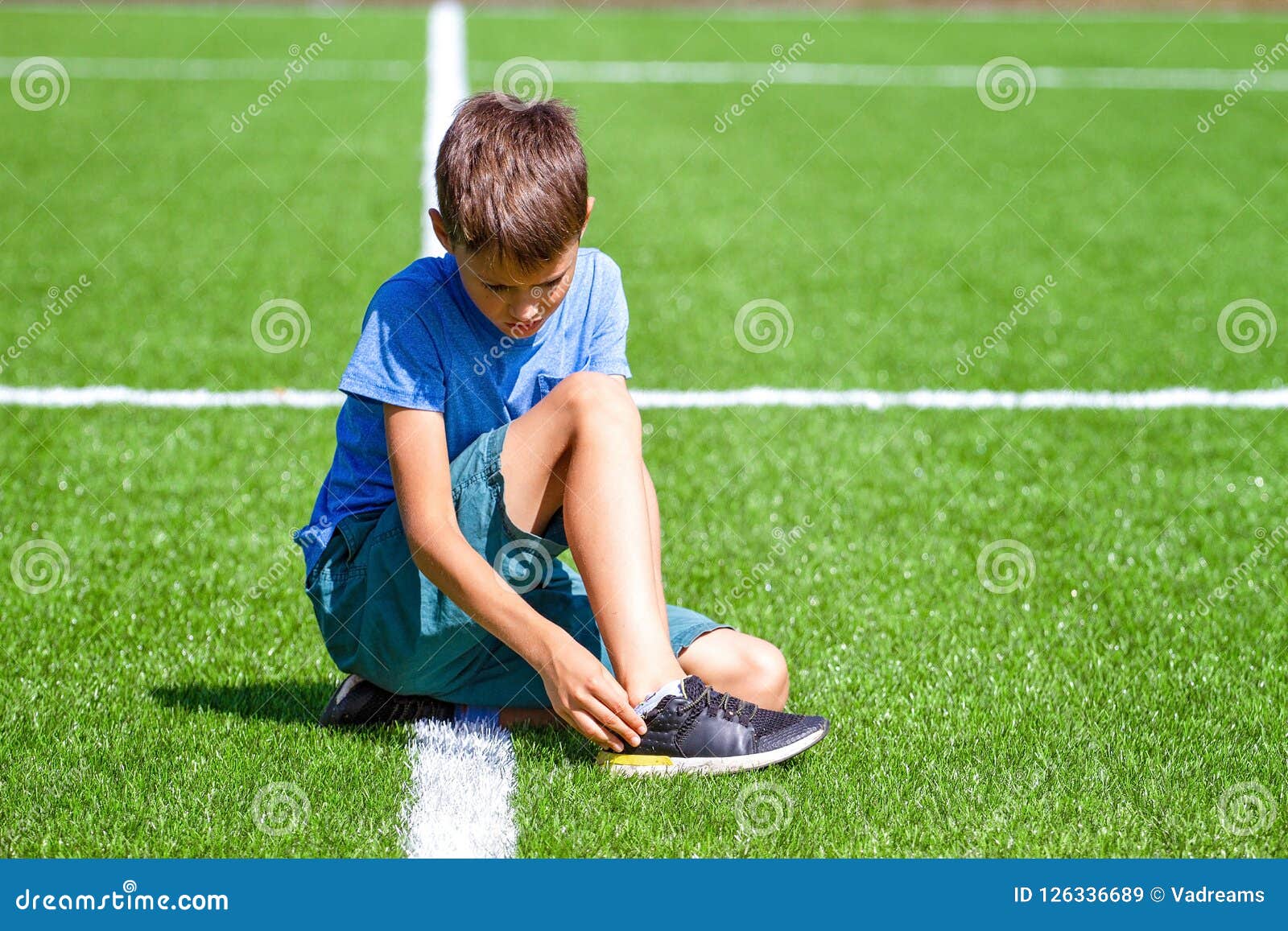 Boy Injured His Leg Child Sitting On The Grass At Soccer Football