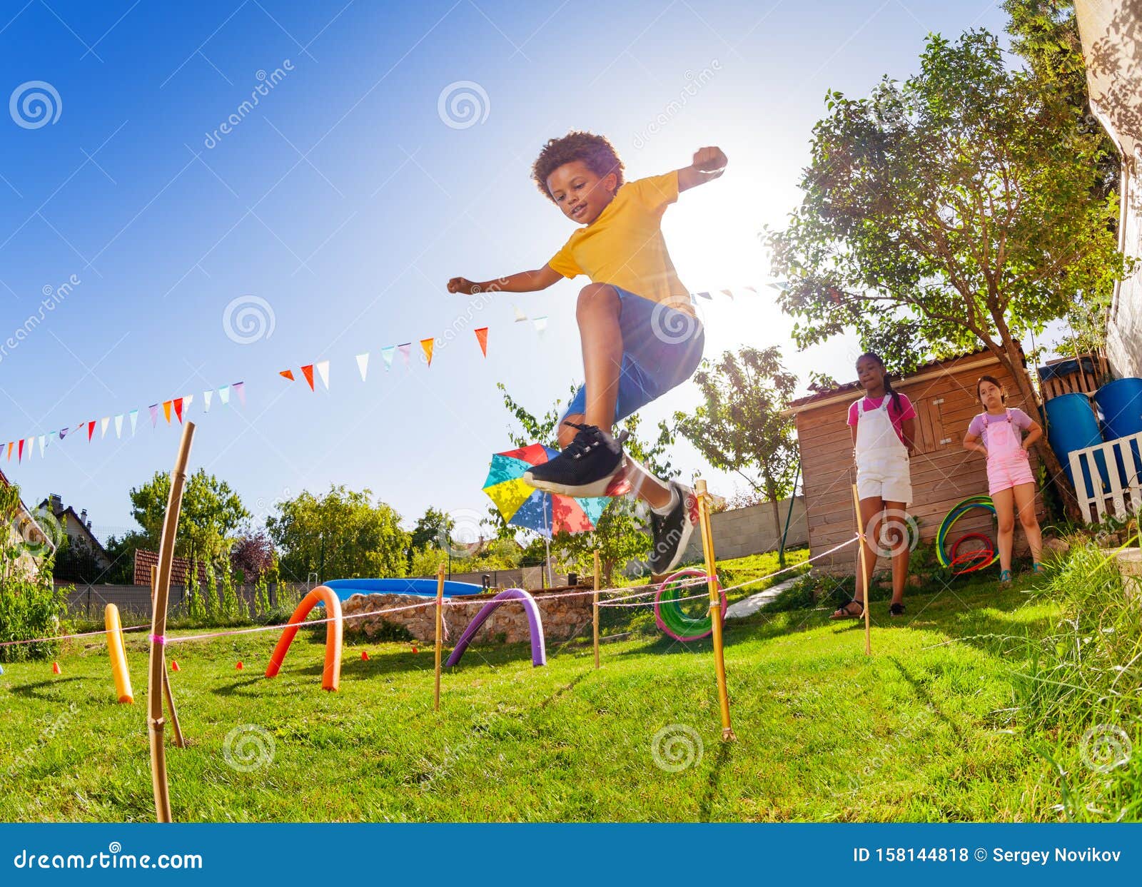 boy jump over strings passing course of obstacles