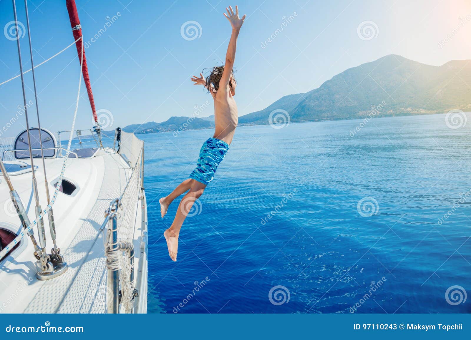 boy jump of sailing yacht on summer cruise. travel adventure, yachting with child