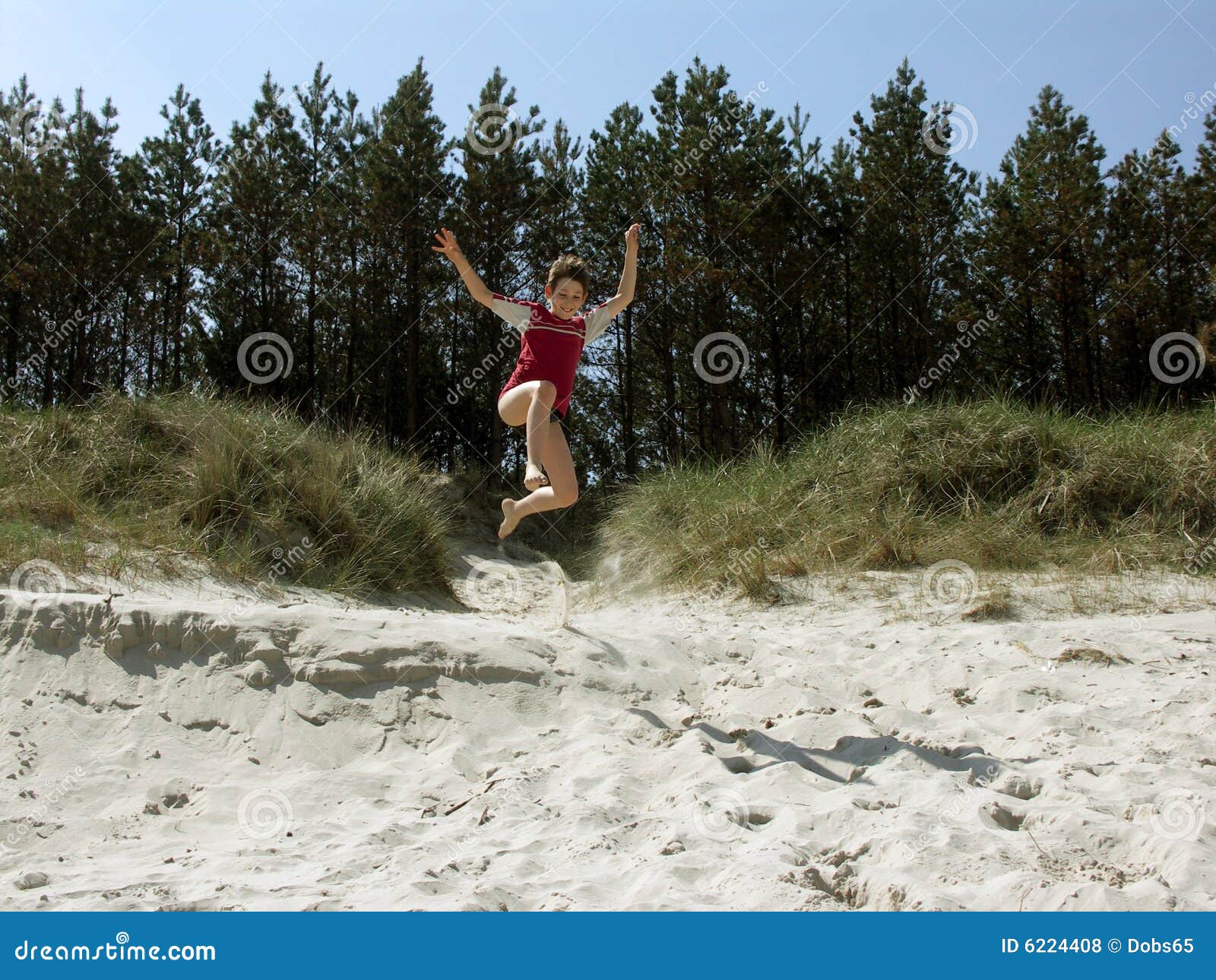 Boy jumping of the dune stock photo. Image of hill, sand 6224408