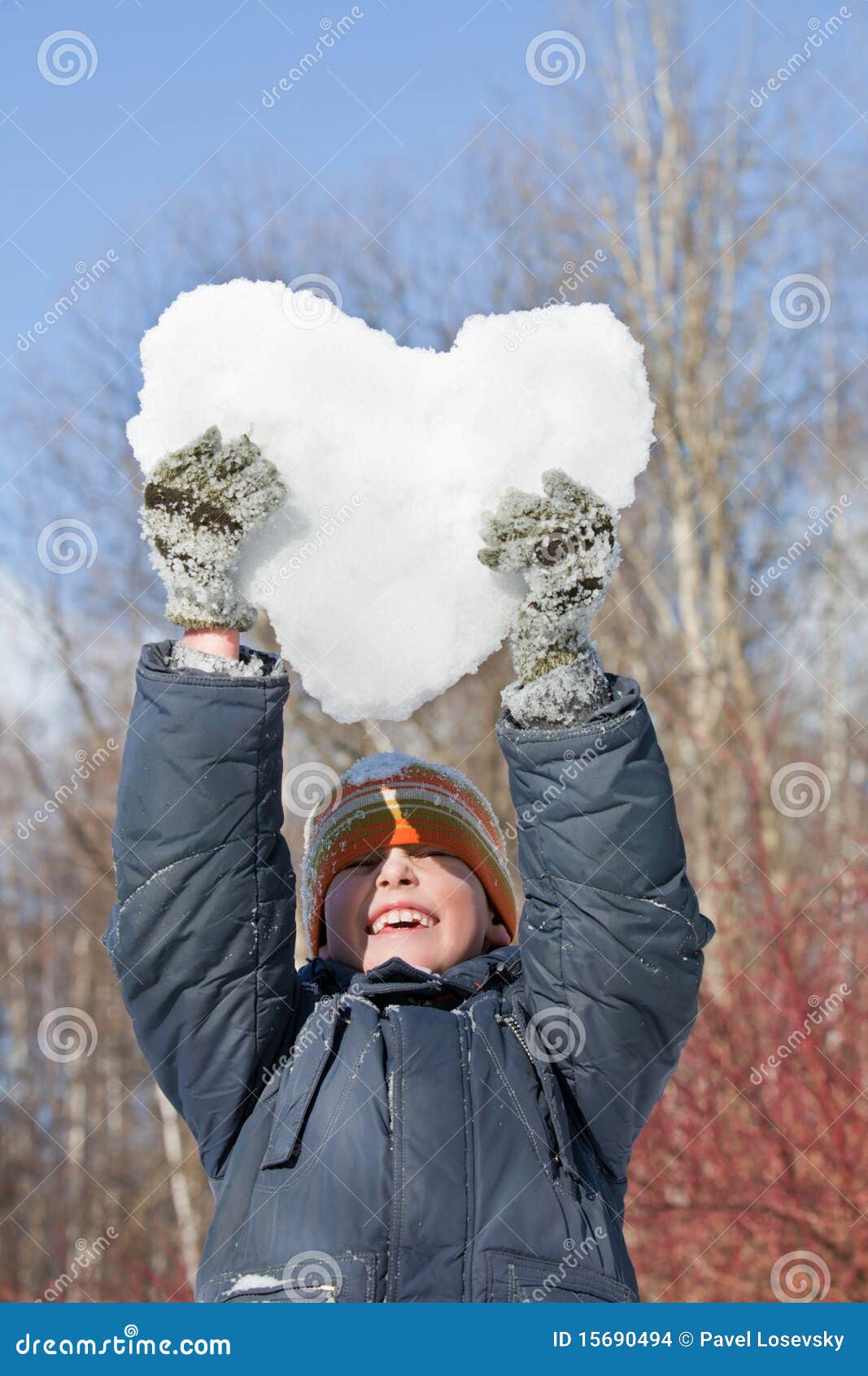 boy keeps in hands hearts from snow over head