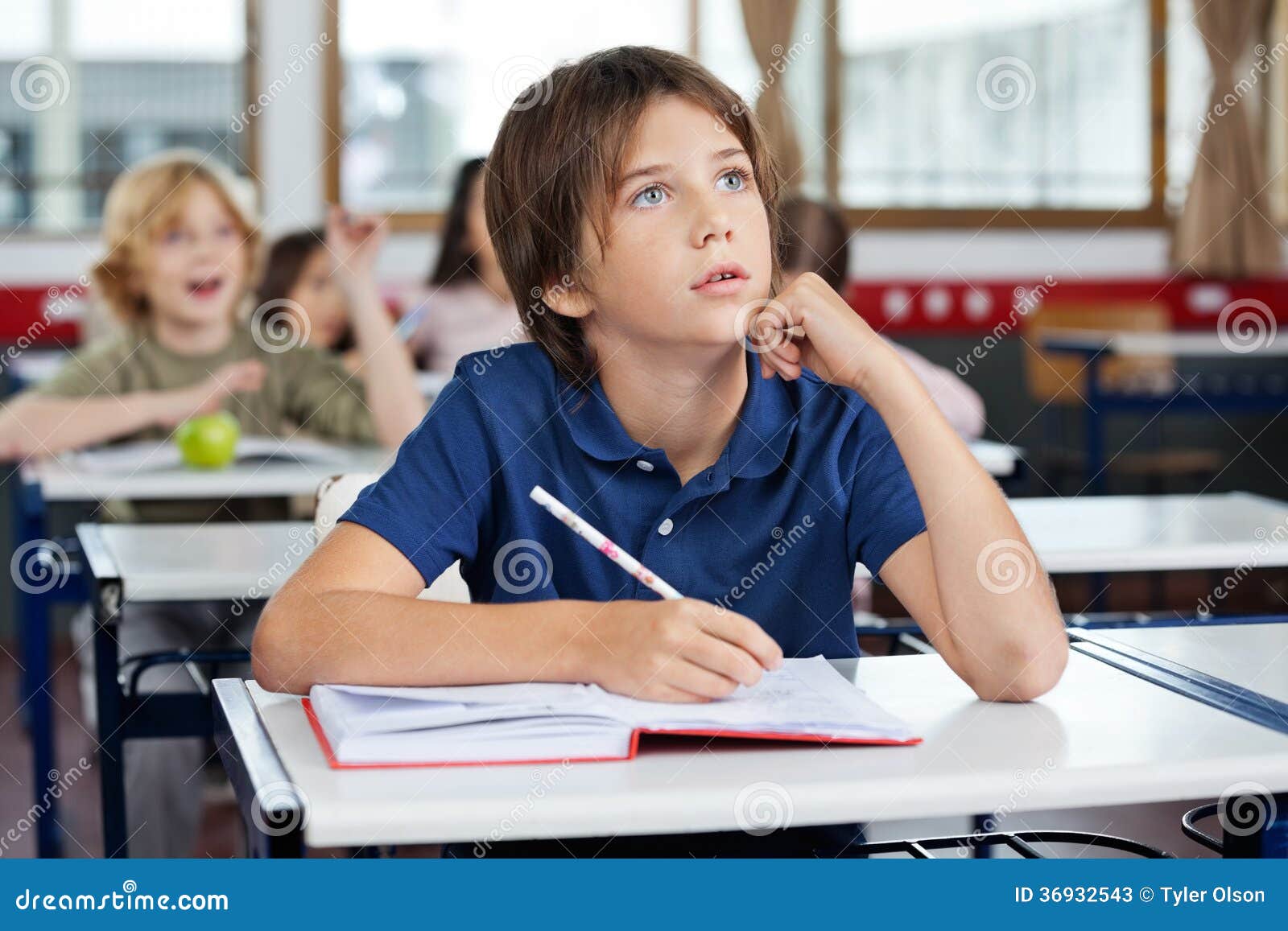 Boy Looking Up while Writing at Desk Stock Image Image of academic