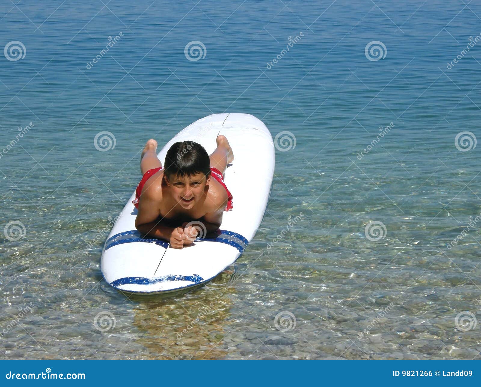 boy lying on surfs in beach