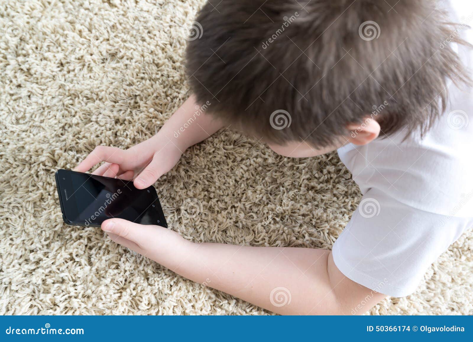 Boy with Phone Lying on a Carpet in the Room Stock Photo Image of