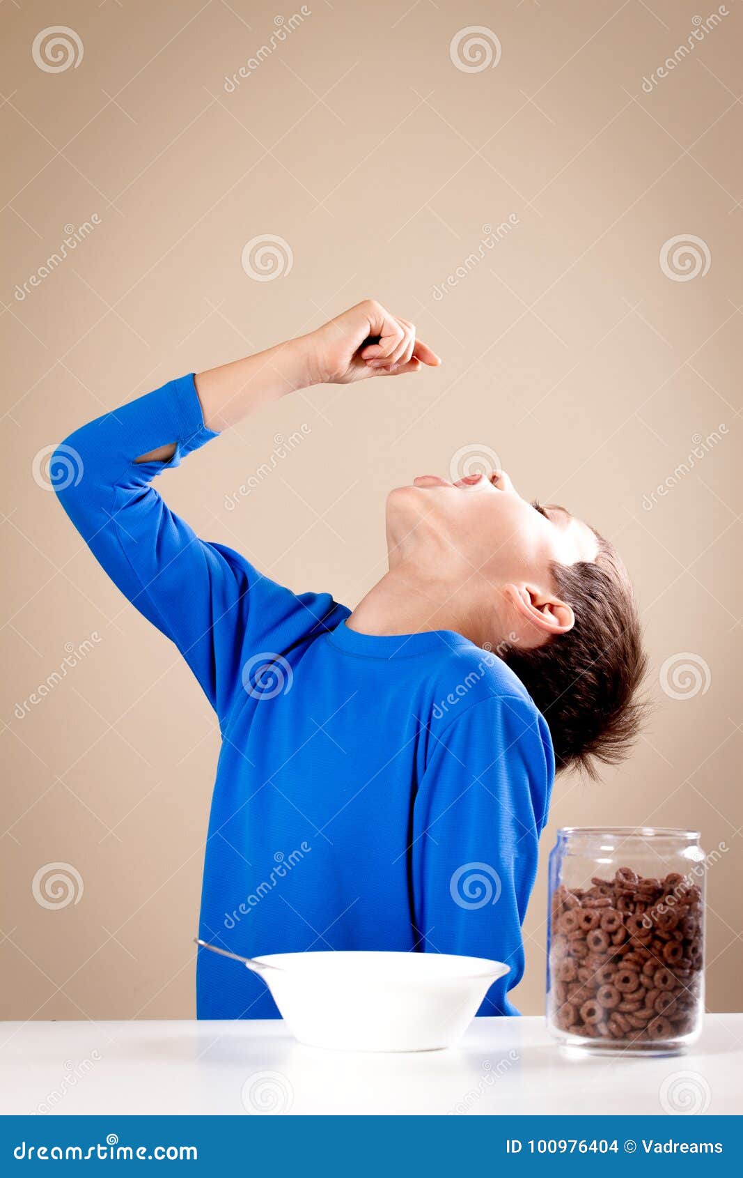Kid Playing during Breakfast. Boy Throwing Cereals To His Mouth Stock