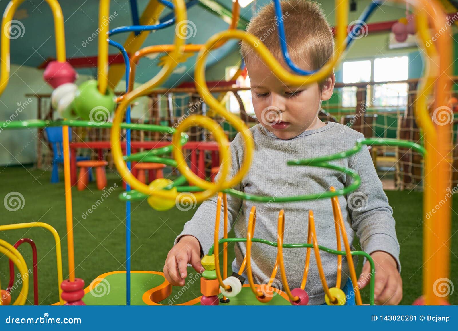 Boy is Playing Educational Toy for Brain Development at Kids Room Stock