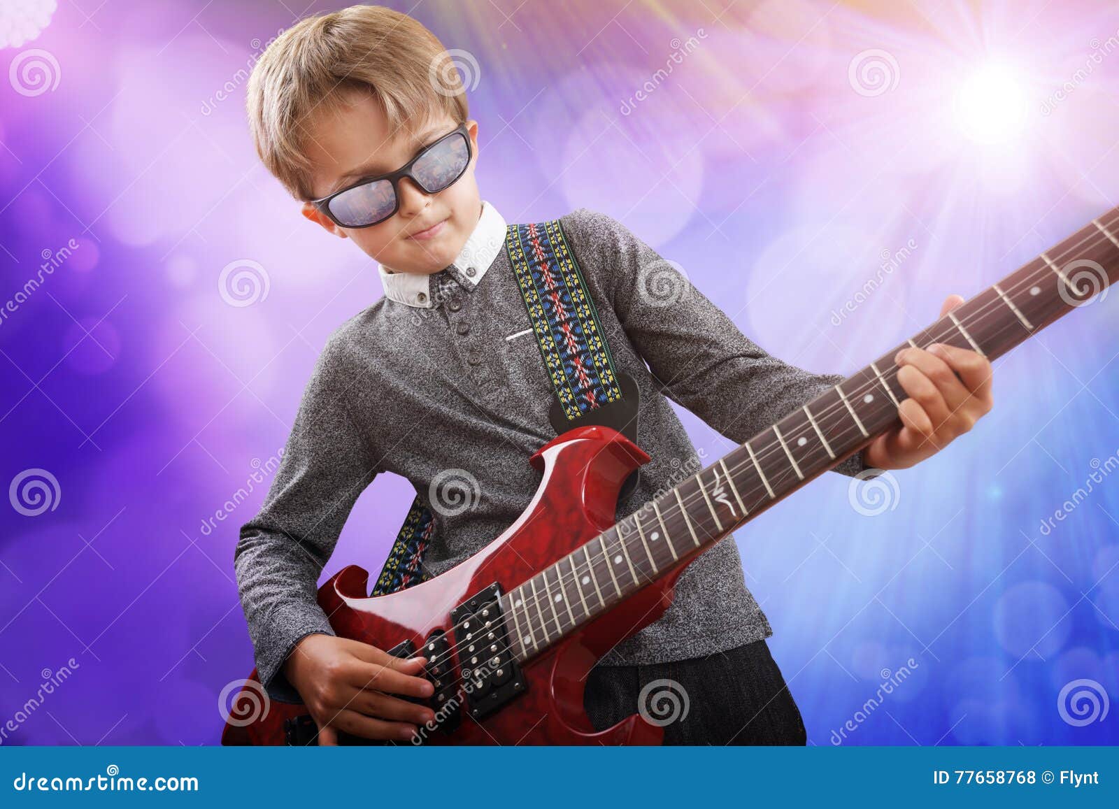 boy playing electric guitar in talent show on stage