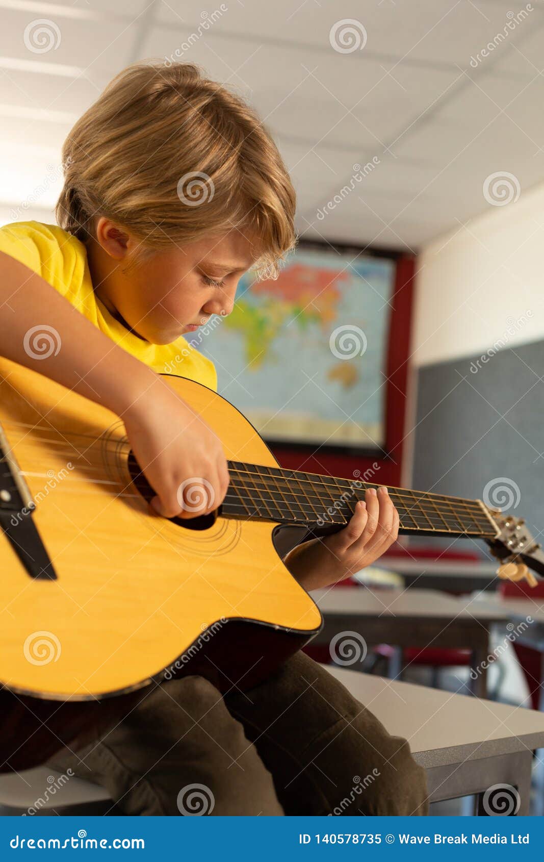 Boy Playing Guitar in a Classroom Stock Image Image of innocence, holding 140578735