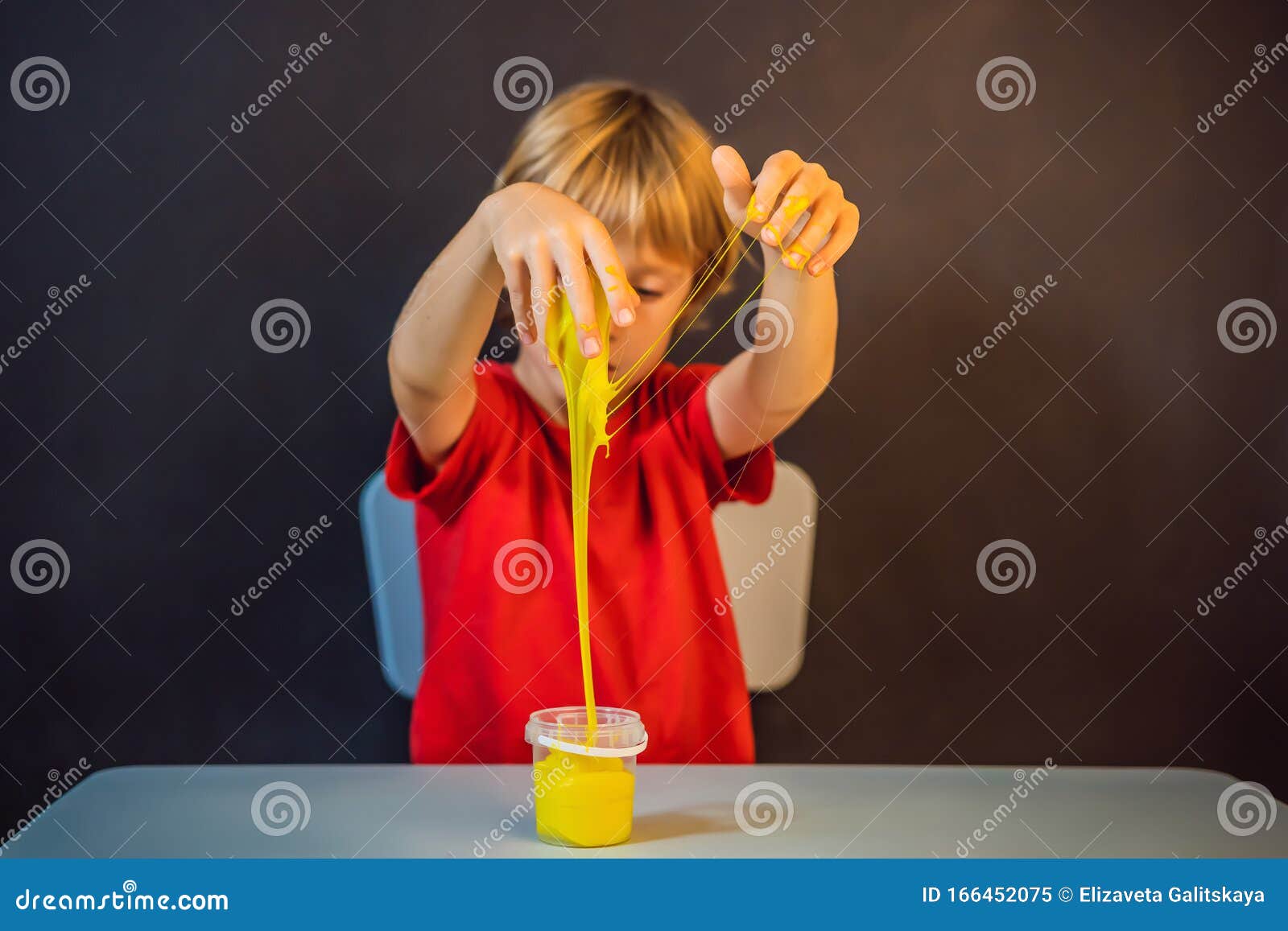boy playing hand made toy called slime. child play with slime. kid squeeze and stretching slime