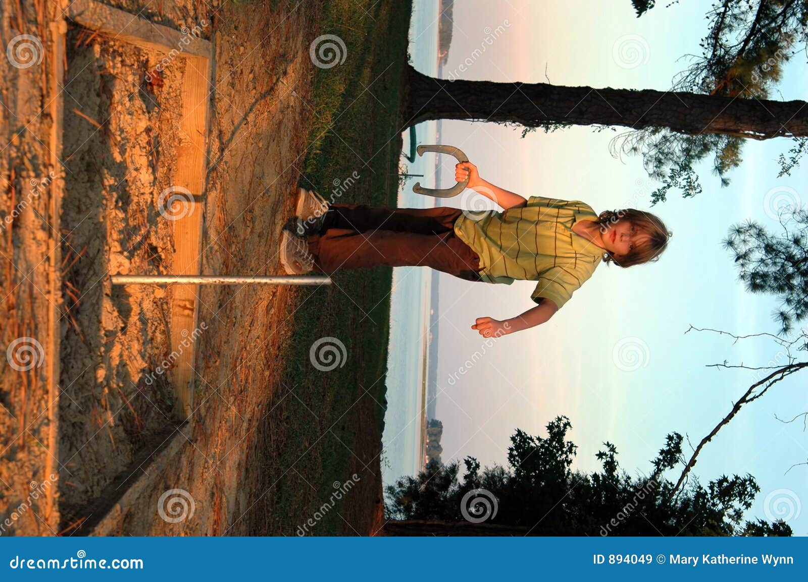 Boy playing horseshoes stock image. Image of lake, game 894049