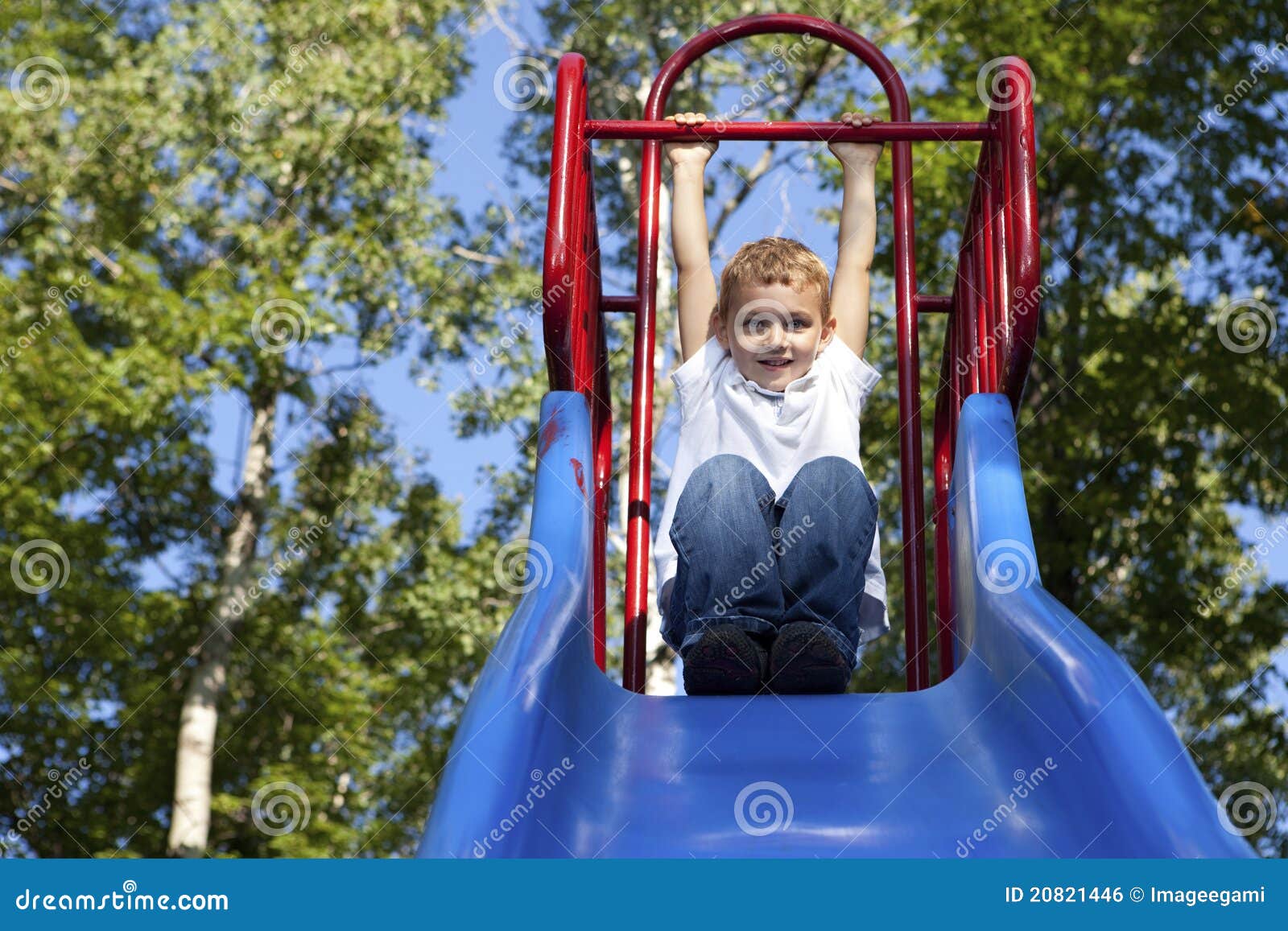 boy playing on a slide at the park
