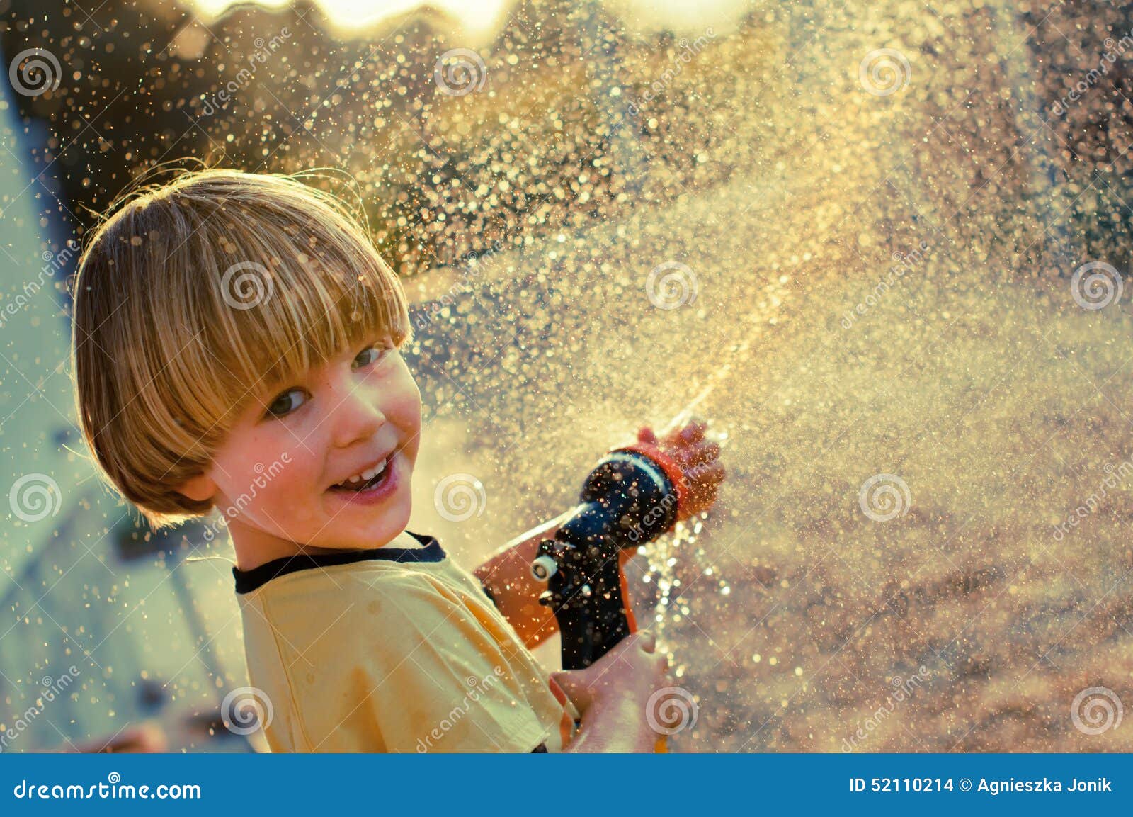 Boy playing with sprinkler stock photo. Image of spray 52110214