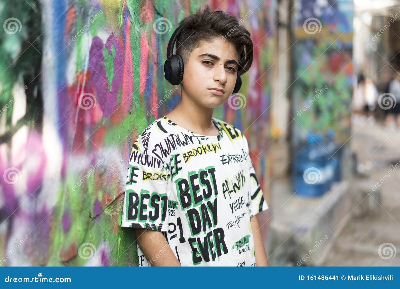 boy portrait with earphones and grafiti behind