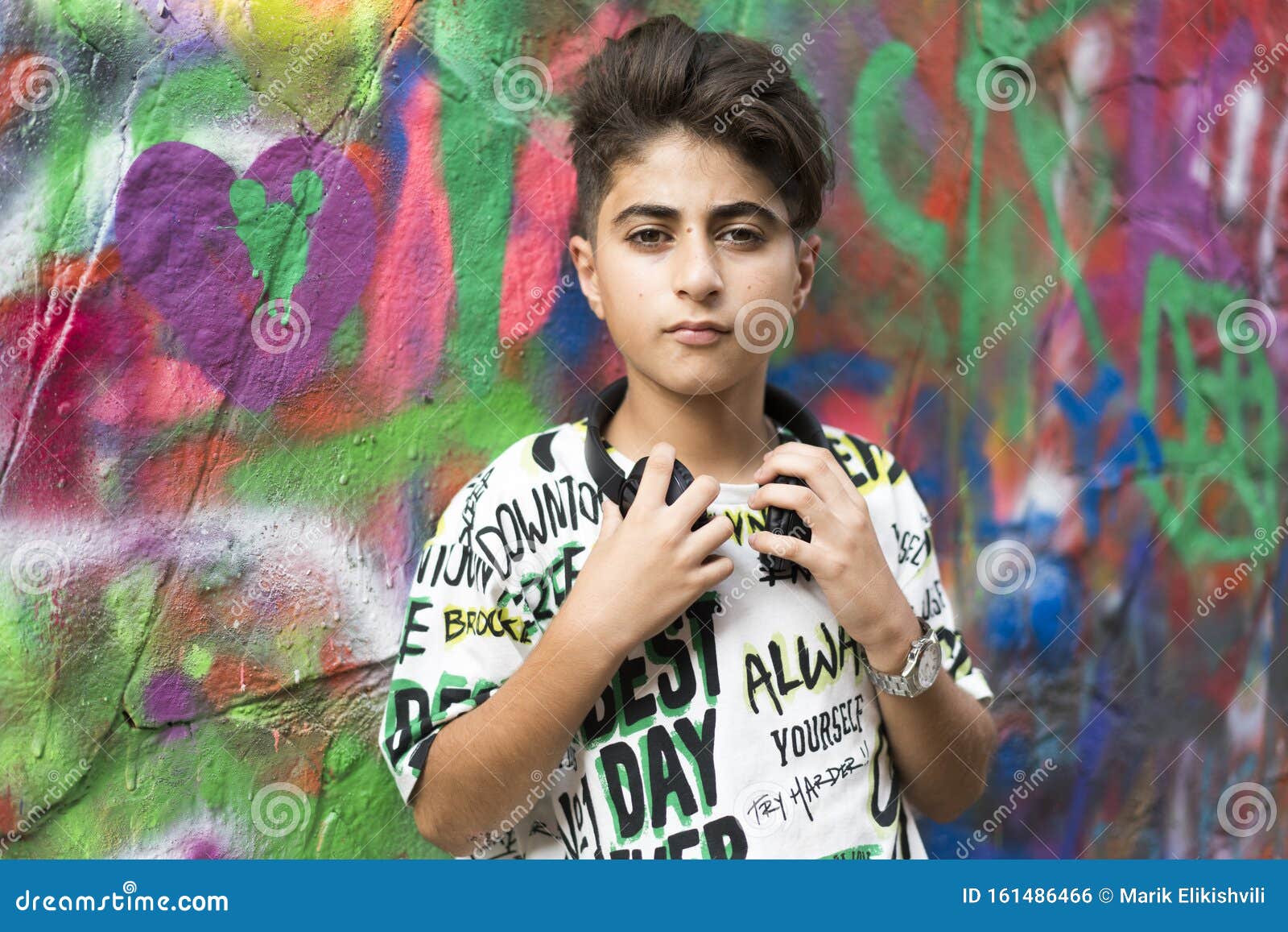 boy portrait with earphones and grafiti behind
