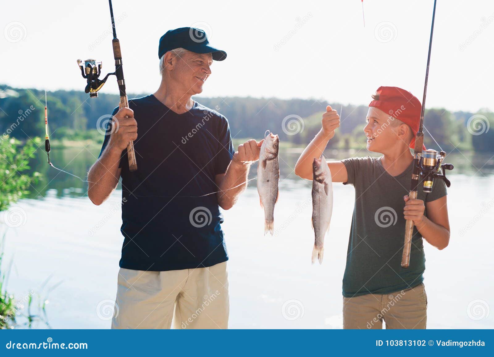 An Old Man and Boy Stand on the River Bank, Holding in Their Hands the  Spinnings, on Which they Caught on a Large Fish Stock Photo - Image of  fishhook, lake: 103813102