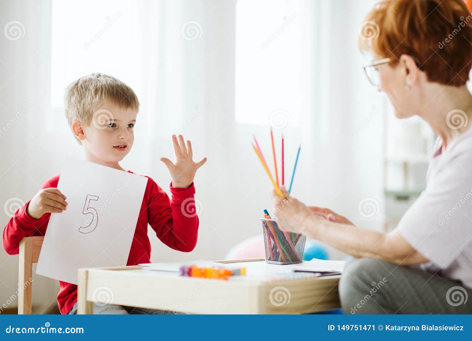 boy in red sweater learning to count during extra-curricular activities