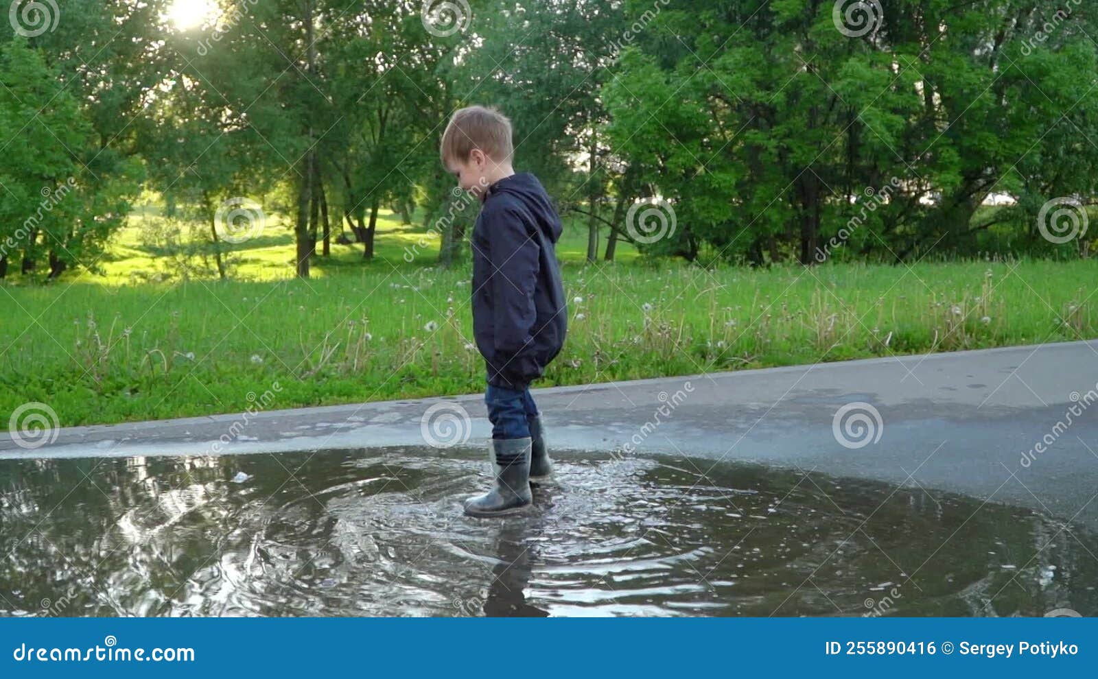 Boy in Rubber Boots Jumping in a Puddle Stock Footage Video of