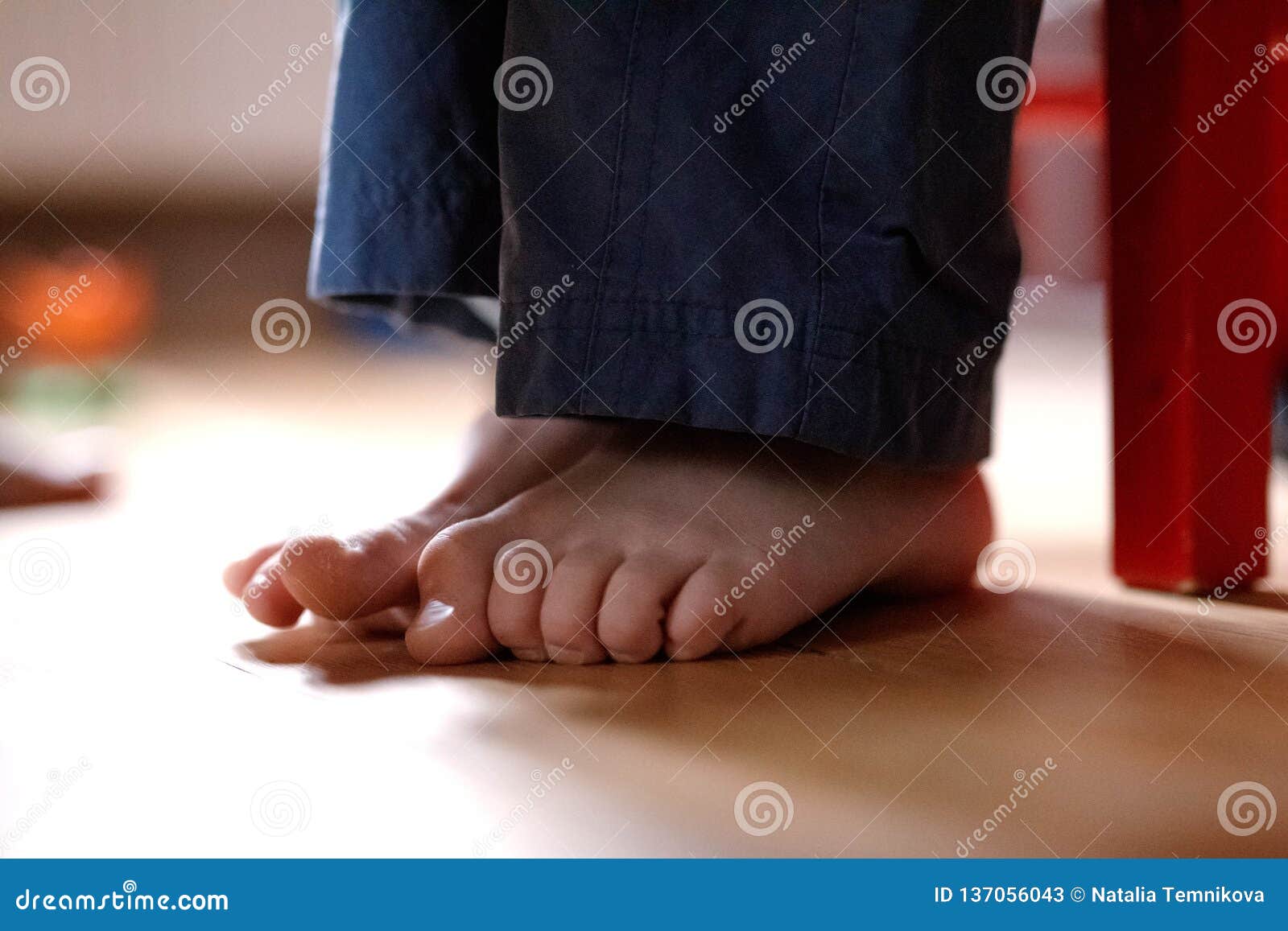 Boy`s feet on the floor stock image. Image of flexibility 137056043