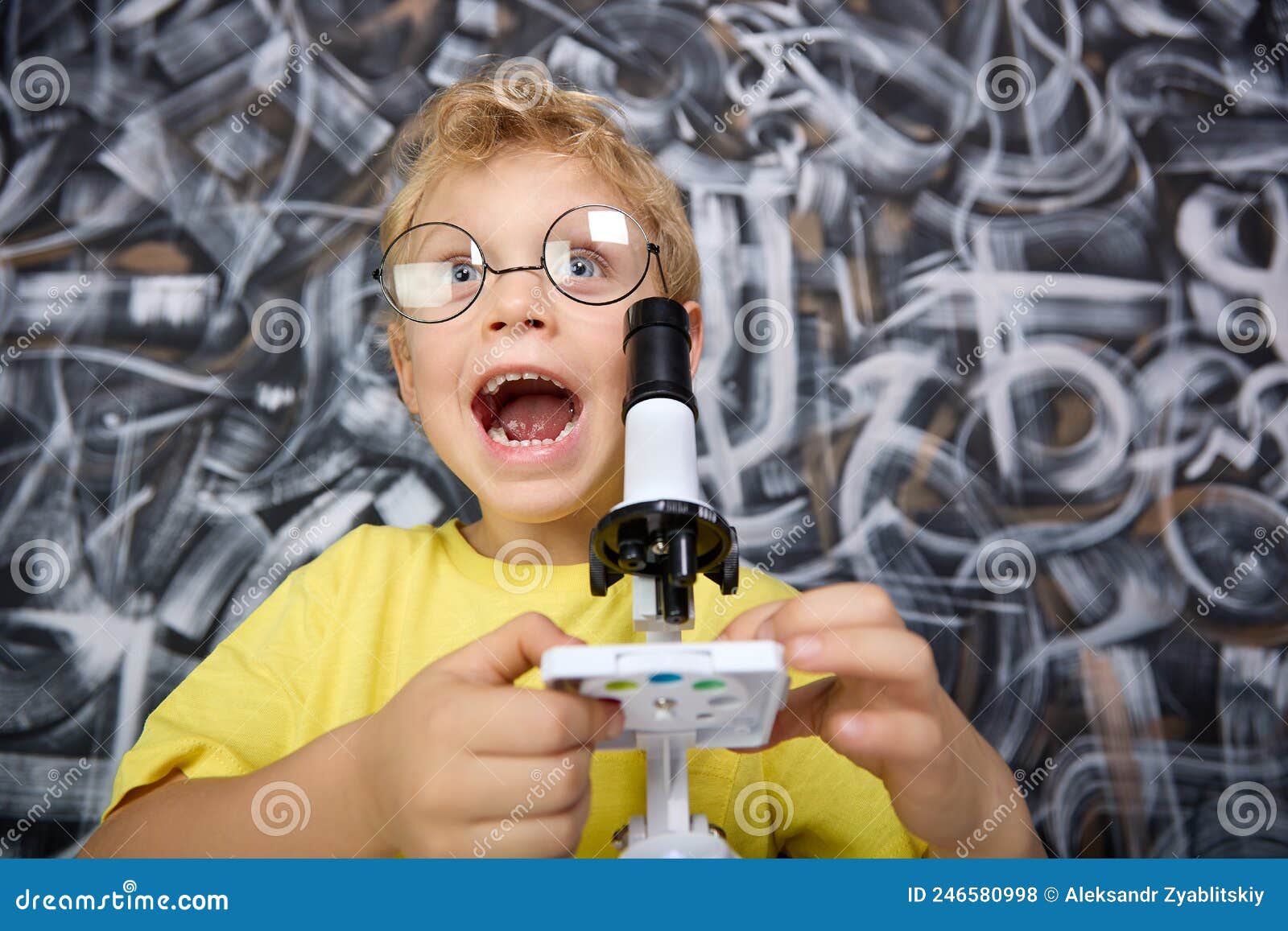 boy screams with delight field of what he saw on stage through a microscope