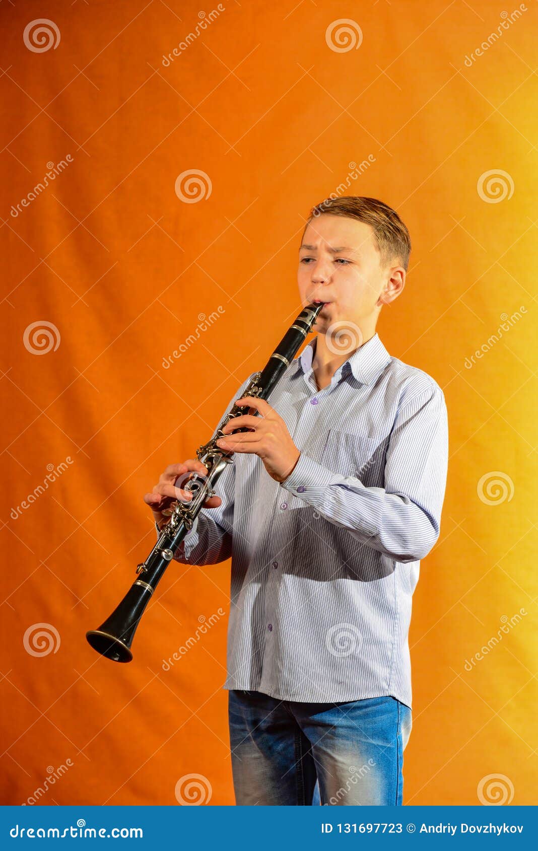 Boy in Shirt and Jeans Plays the on a Yellow Background Stock