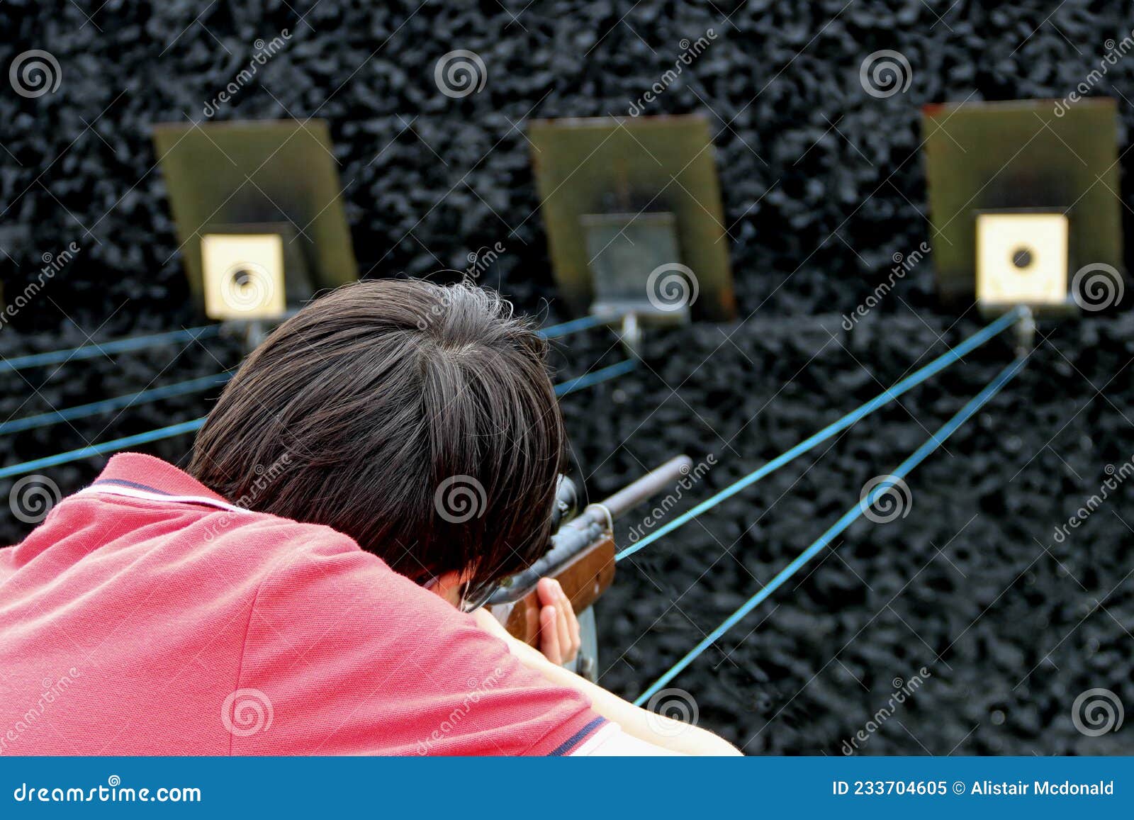 boy shooting a rifle at a country show shooting gallery