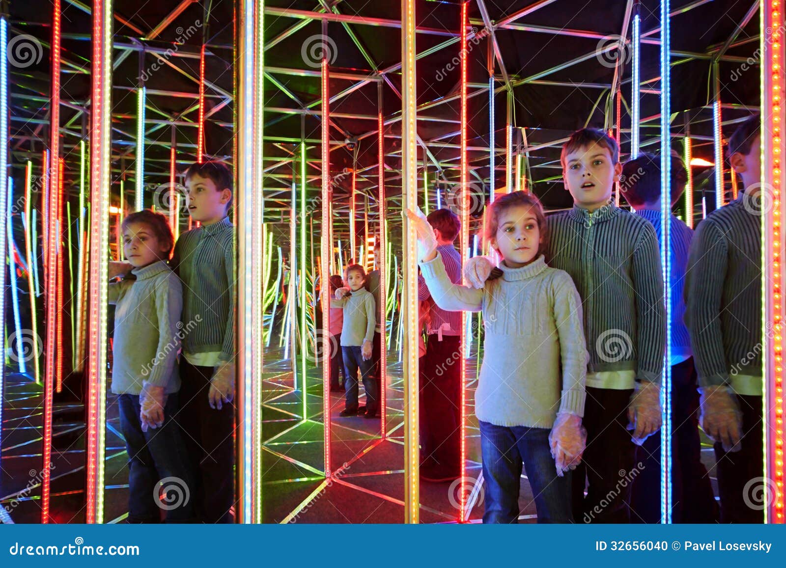 boy and sister wander in semidarkness of mirror labyrinth