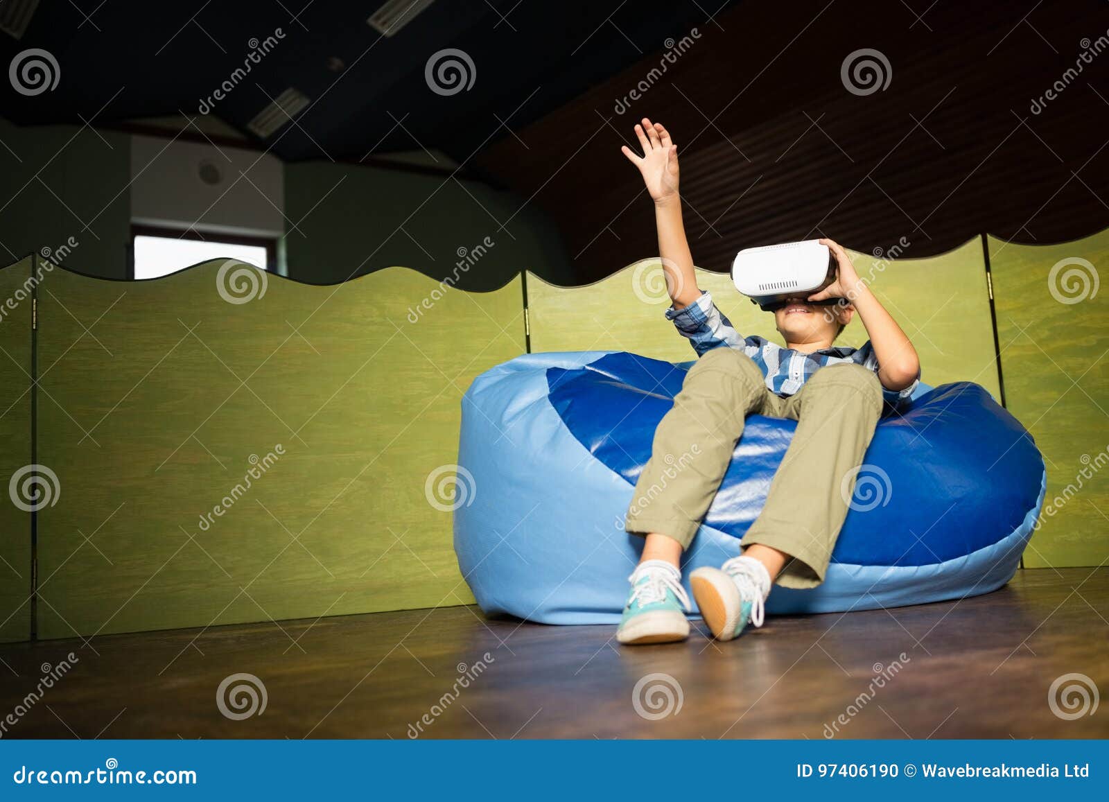 Boy Sitting on Bean Bag and Using Virtual Reality Headset Stock Photo