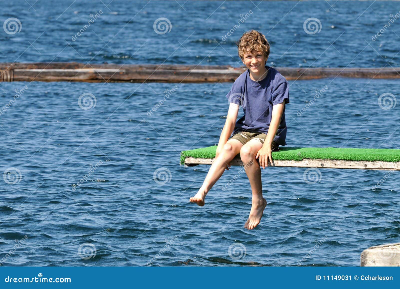 Boy Sitting On Diving Board At Lake Stock Image Image 11149031