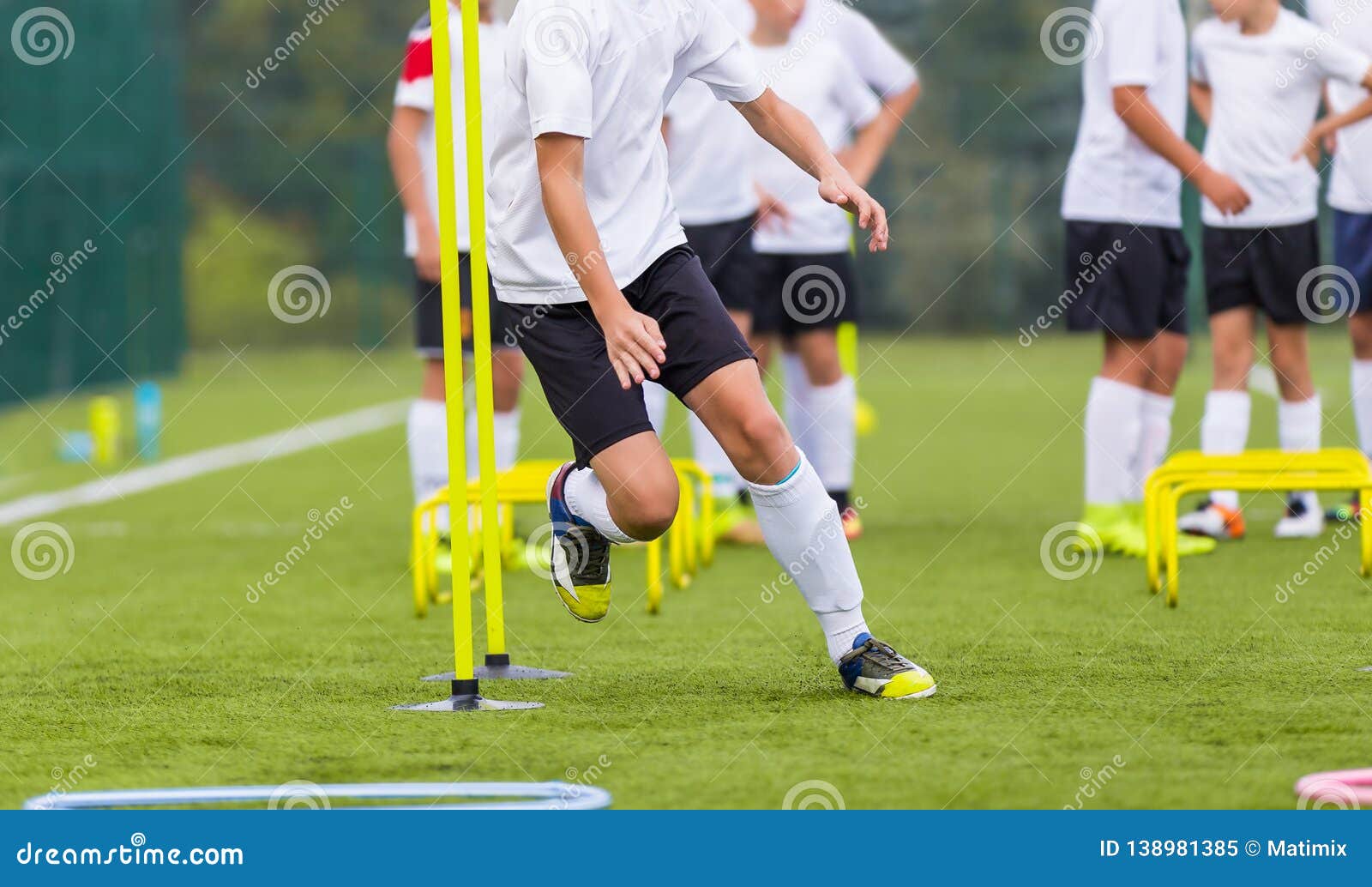 boy soccer player in training. boy running between cones during practice in field