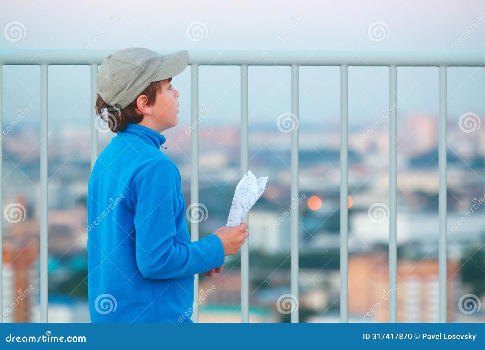 boy stands on roof of multistory building with