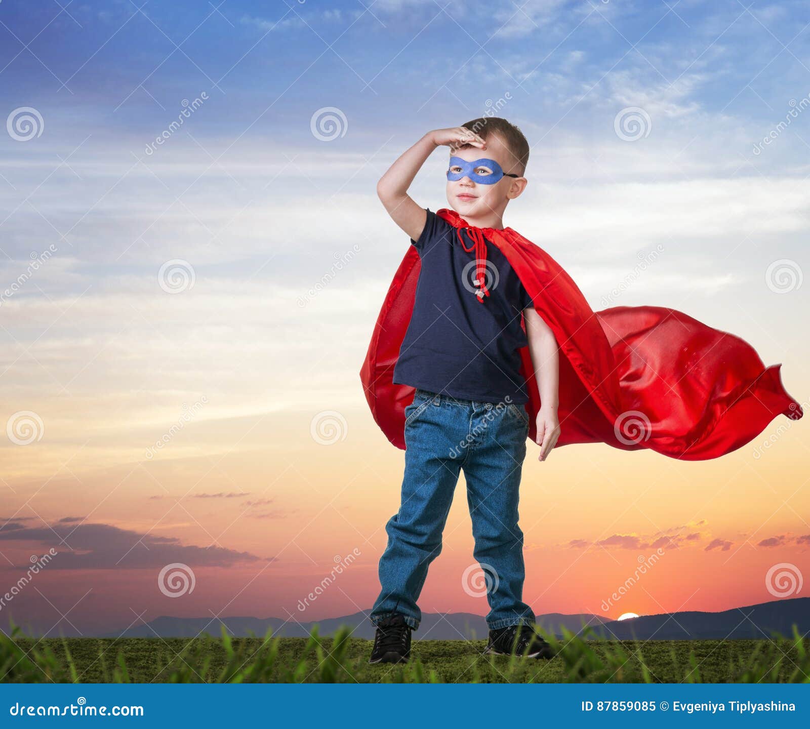 a boy in a superman costume stands