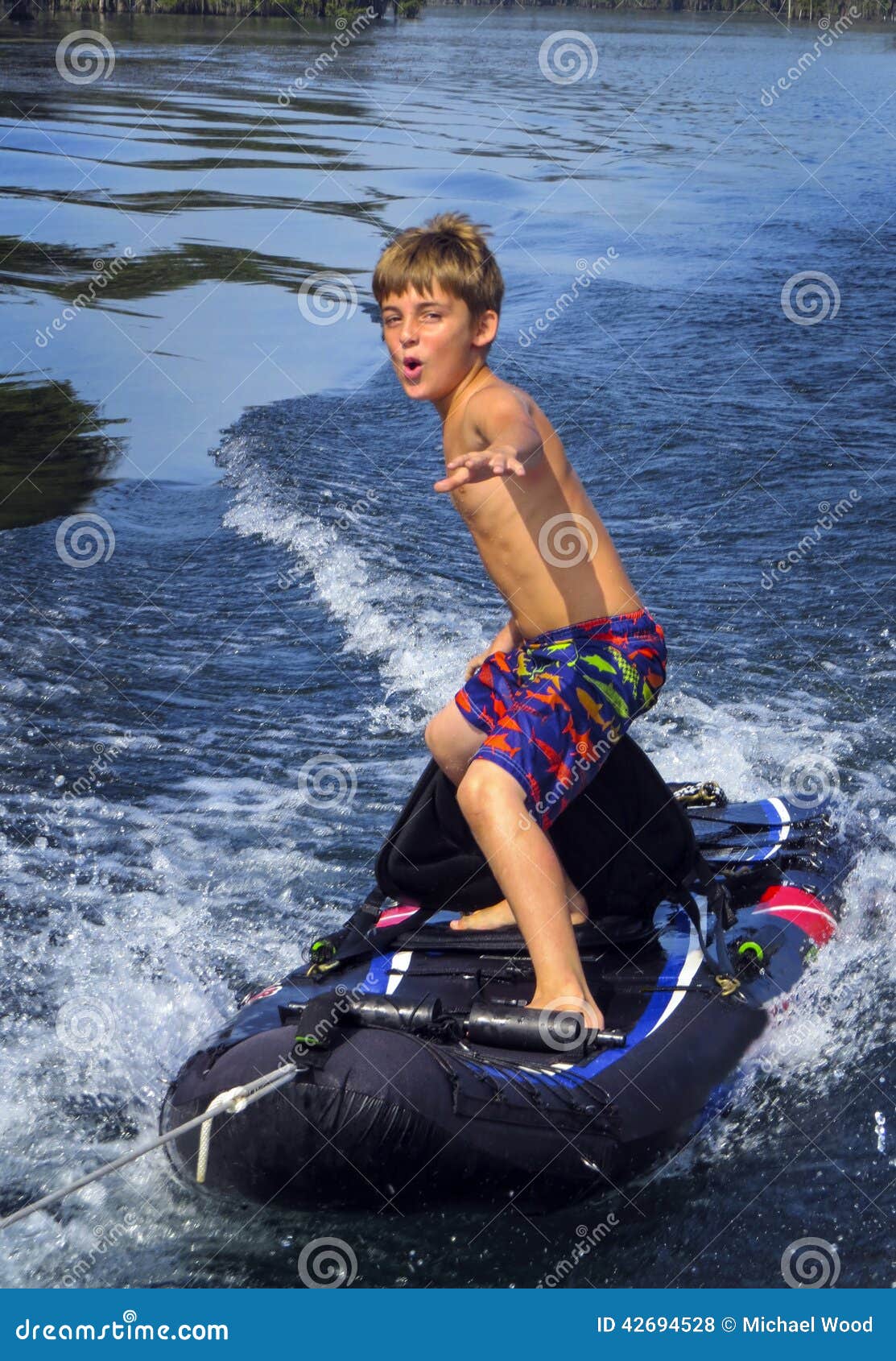 Boy Surfs Kayak - Boat Tow stock photo. Image of merritts 
