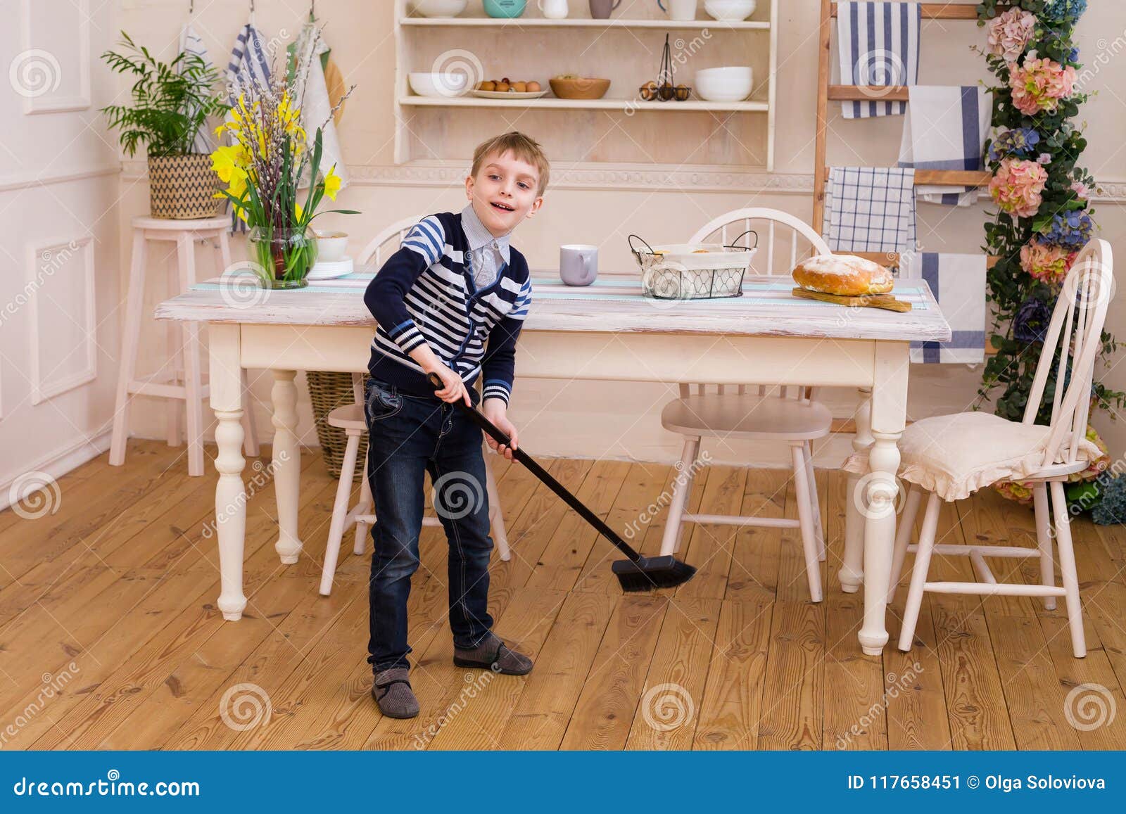 Boy Sweeping the Floor in the Kitchen. Pretty Boy Helps Parents Stock ...