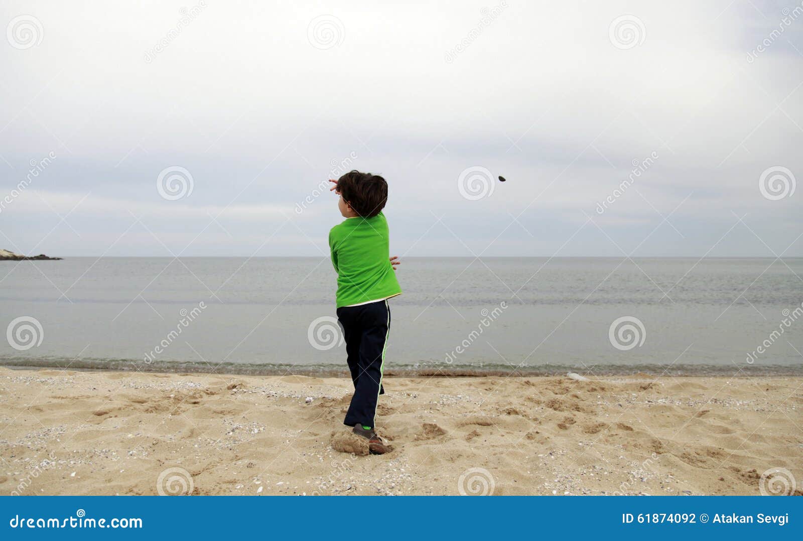 A Boy Throwing Stone into the Sea Stock Photo Image of caucasian