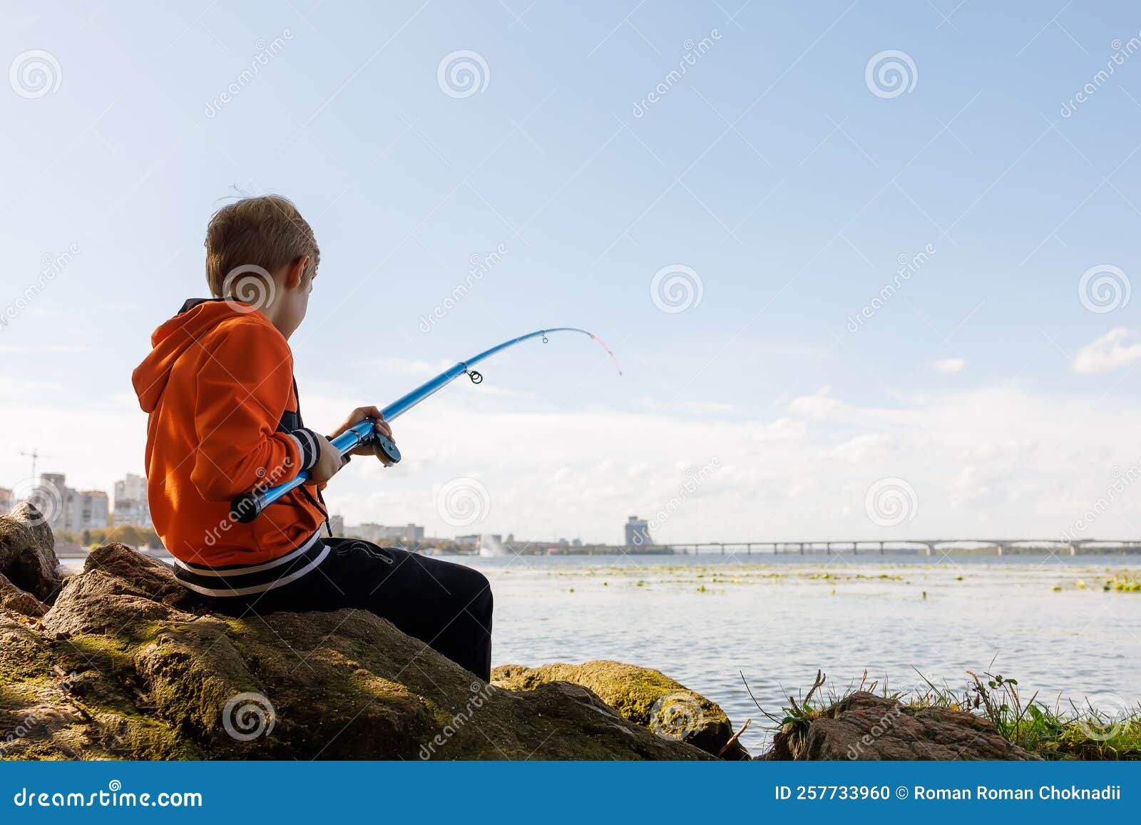 The Boy is Trying To Pull the Fish Out of the River with the Help of a  Fishing Rod, His Fishing Rod Bends from the Fish Stock Photo - Image of  autumn