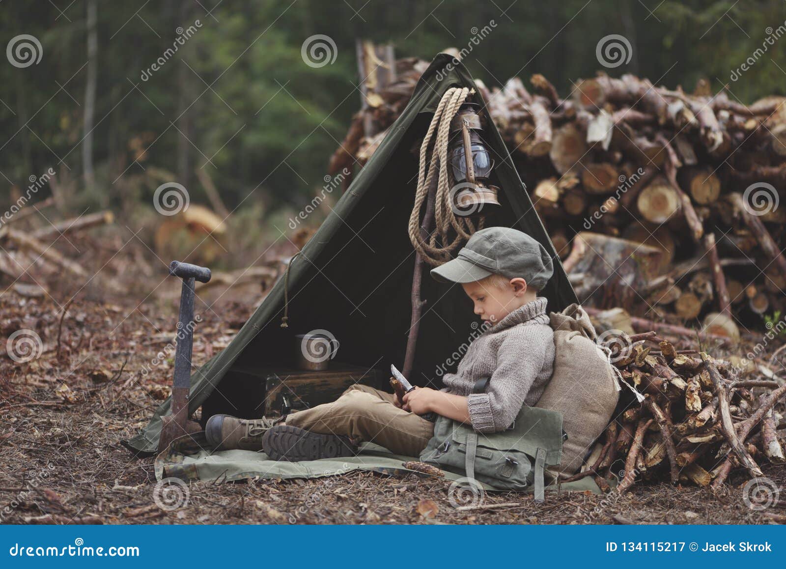 the boy, 5 years old, looks like a trapper, wanderer, lumberjack.