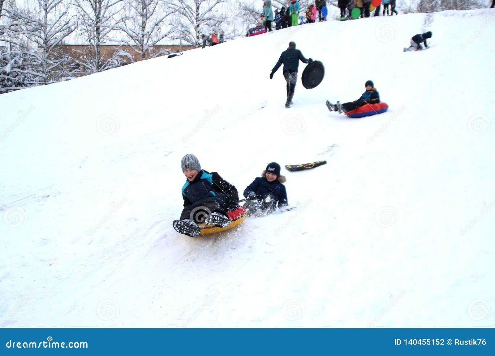 The Boys Go Down On A Sled From A Snow Slide Clinging To