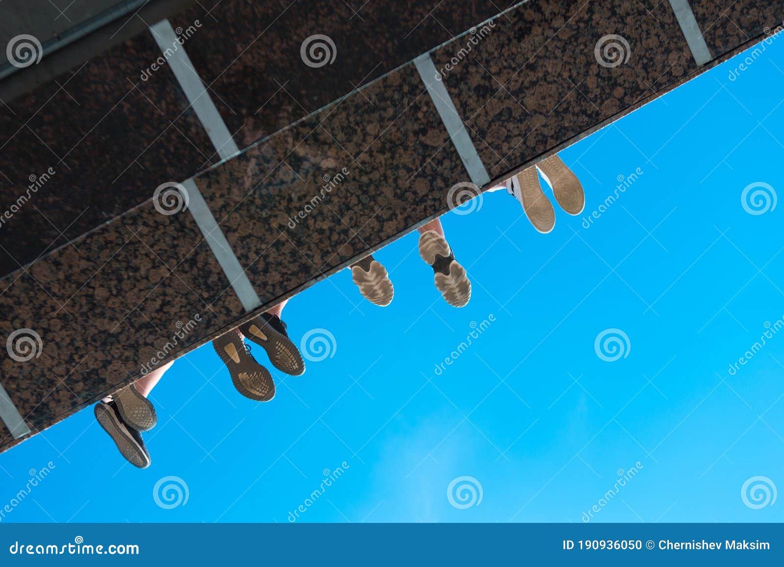 Boys Legs in Shoes Hanging from the Bridge Against Blue Sky Stock Photo ...