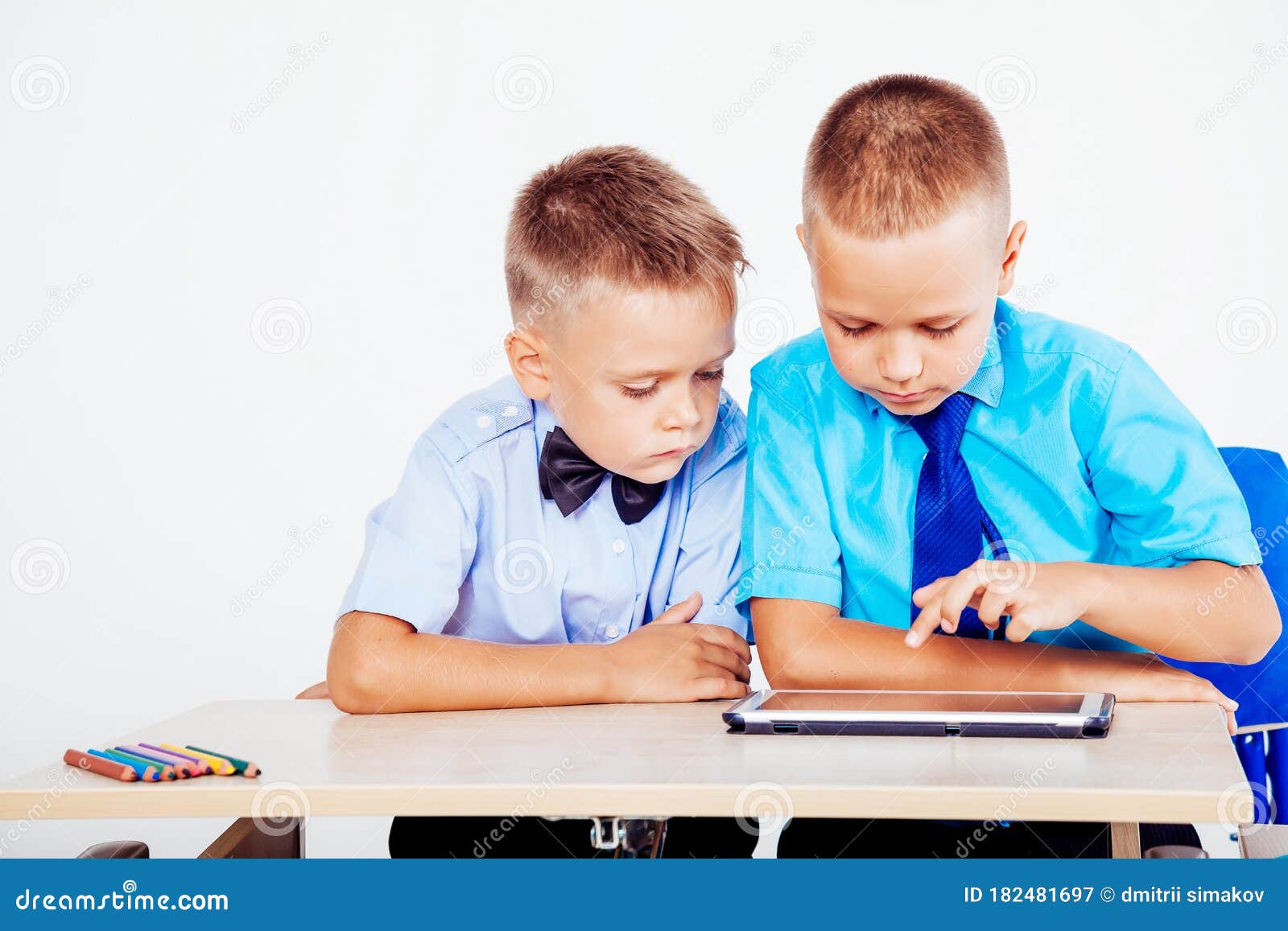Boys Sit at a Desk and Looking Tablet Stock Image Image of group