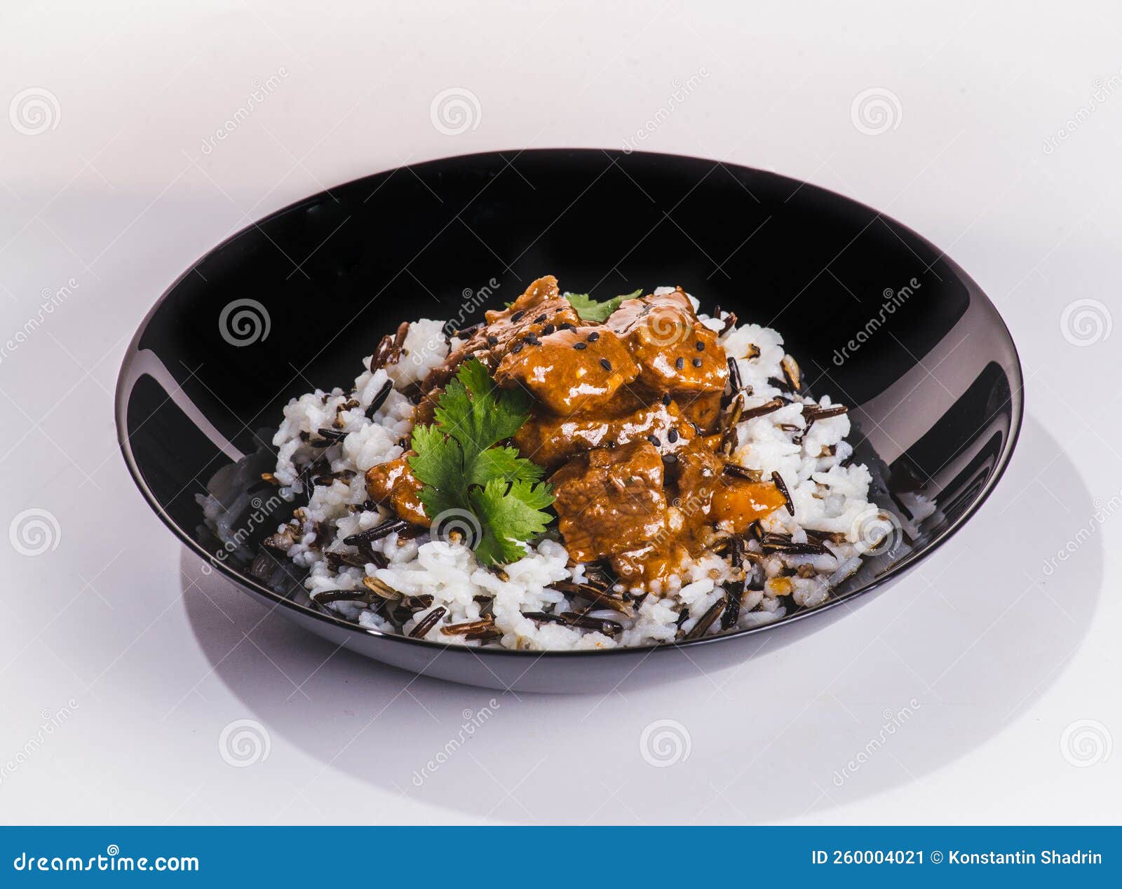 Braised Beef in Red Wine with Wild Rice and Vegetables in a White Plate
