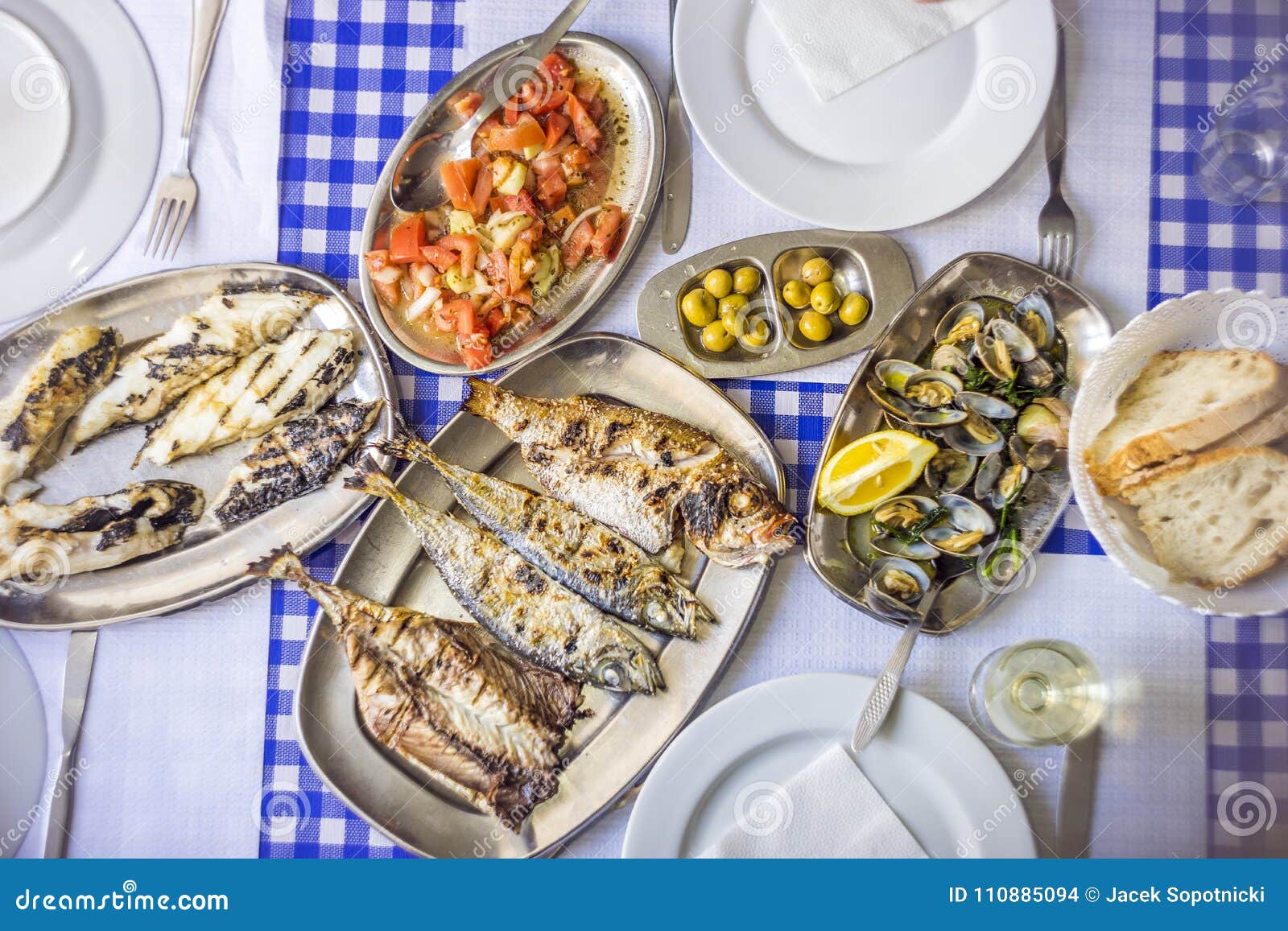 Branzino arrostito col barbecue, dorato, sgombro di accompagnamento con il toma. Festività del pesce: branzino, dorato, sgombri di accompagnamento con l'insalata del pomodoro, vongole, pane e vino bianco, Portogallo