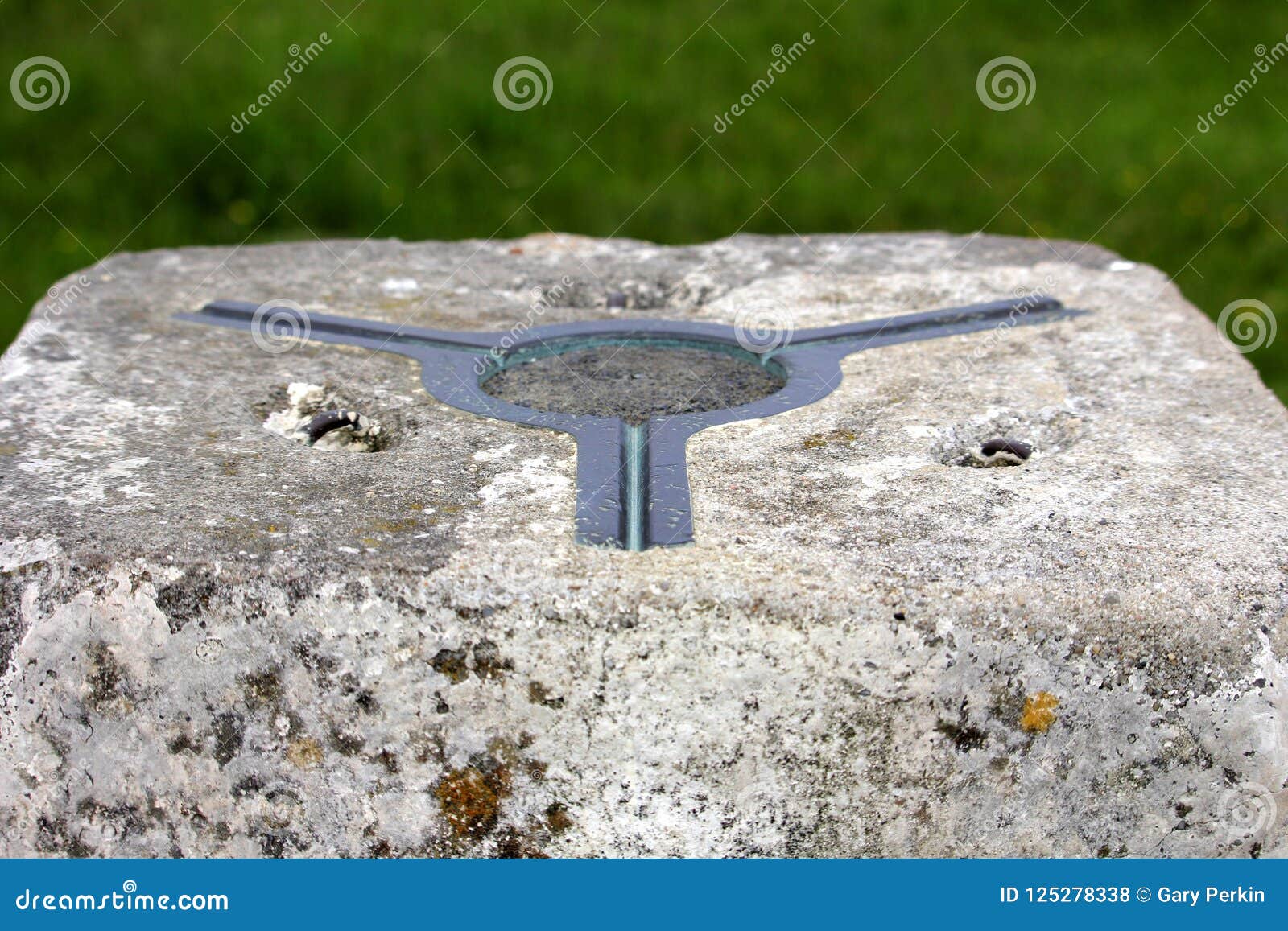 the brass plate used as a mounting point for a theodolite on top of a concrete british ordnance survey triangulation point, or tri